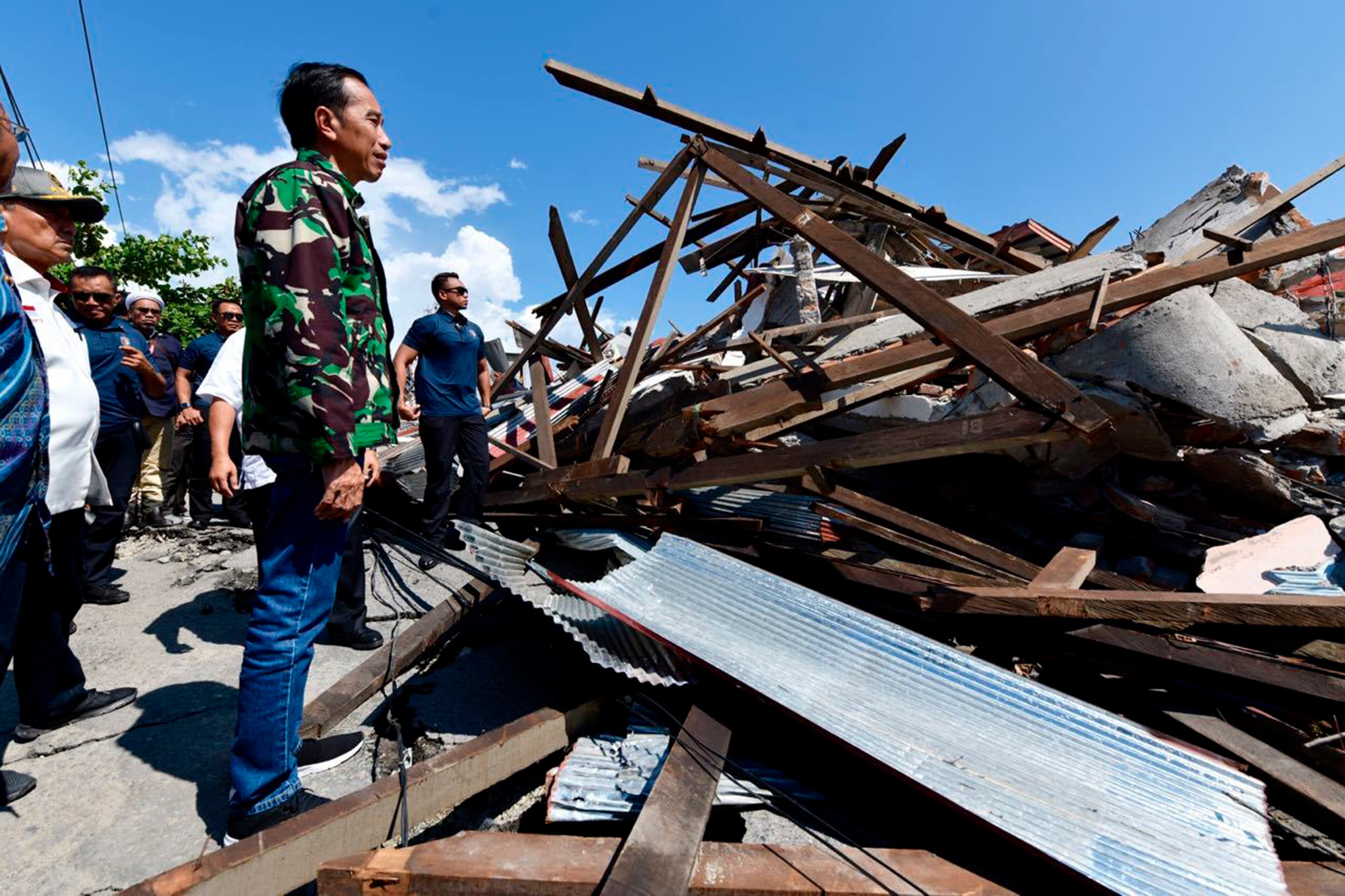 In this photo released by the Indonesian Presidential Office, Indonesian President Joko Widodo walks at the damage area following earthquakes and a tsunami in Palu, Central Sulawesi, Indonesia, Sunday, Sept. 30, 2018. Rescuers were scrambling Sunday to try to find trapped victims in collapsed buildings where voices could be heard screaming for help after a massive earthquake in Indonesia spawned a deadly tsunami two days ago.(Agus Suparto/Indonesian Presidential Office via AP)