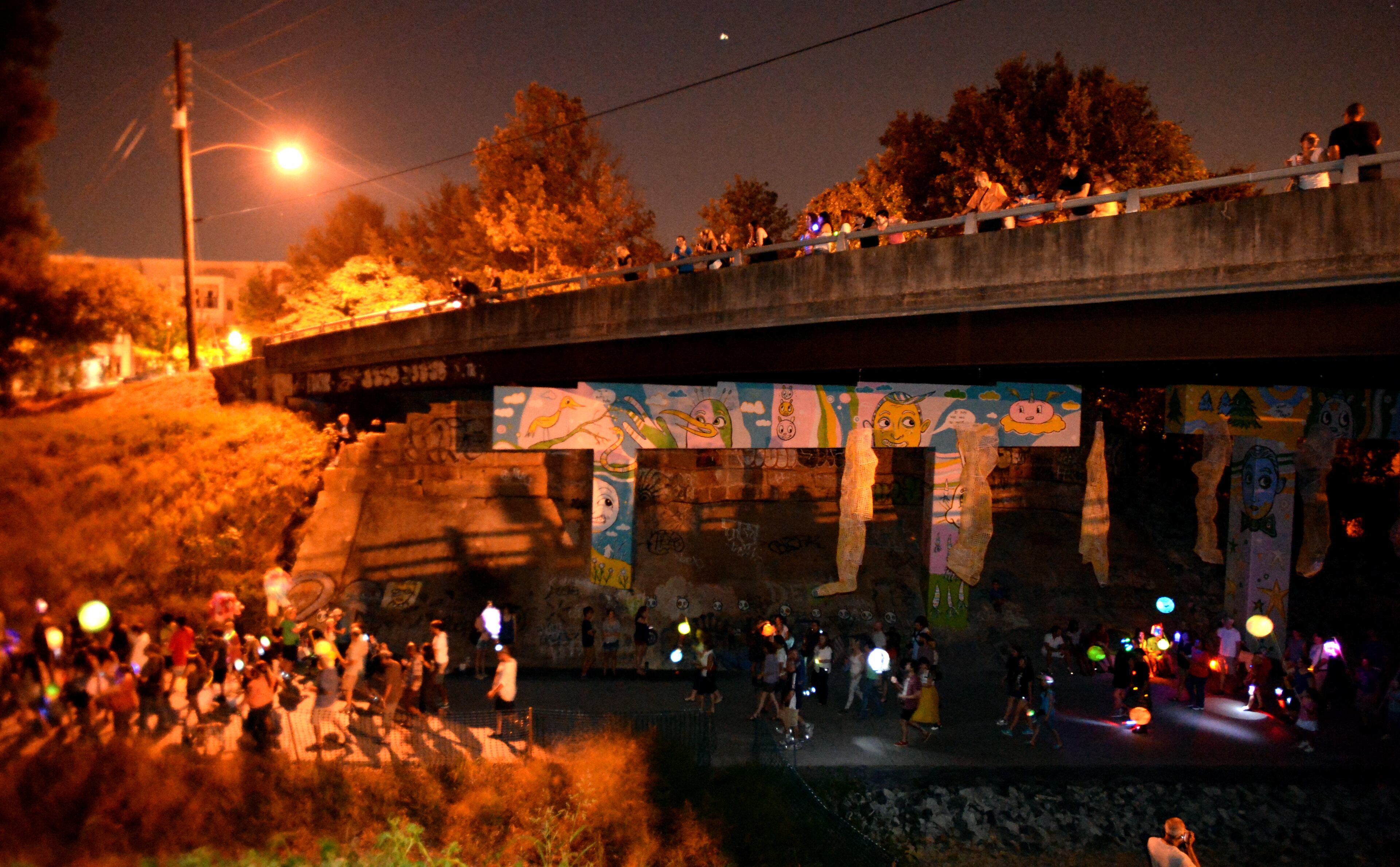 Spectators watch hundreds of parade participants floating on the Eastside Trail of the Atlanta BeltLine during the 2013 Atlanta BeltLine Lantern Parade on Sept. 7, 2013.
