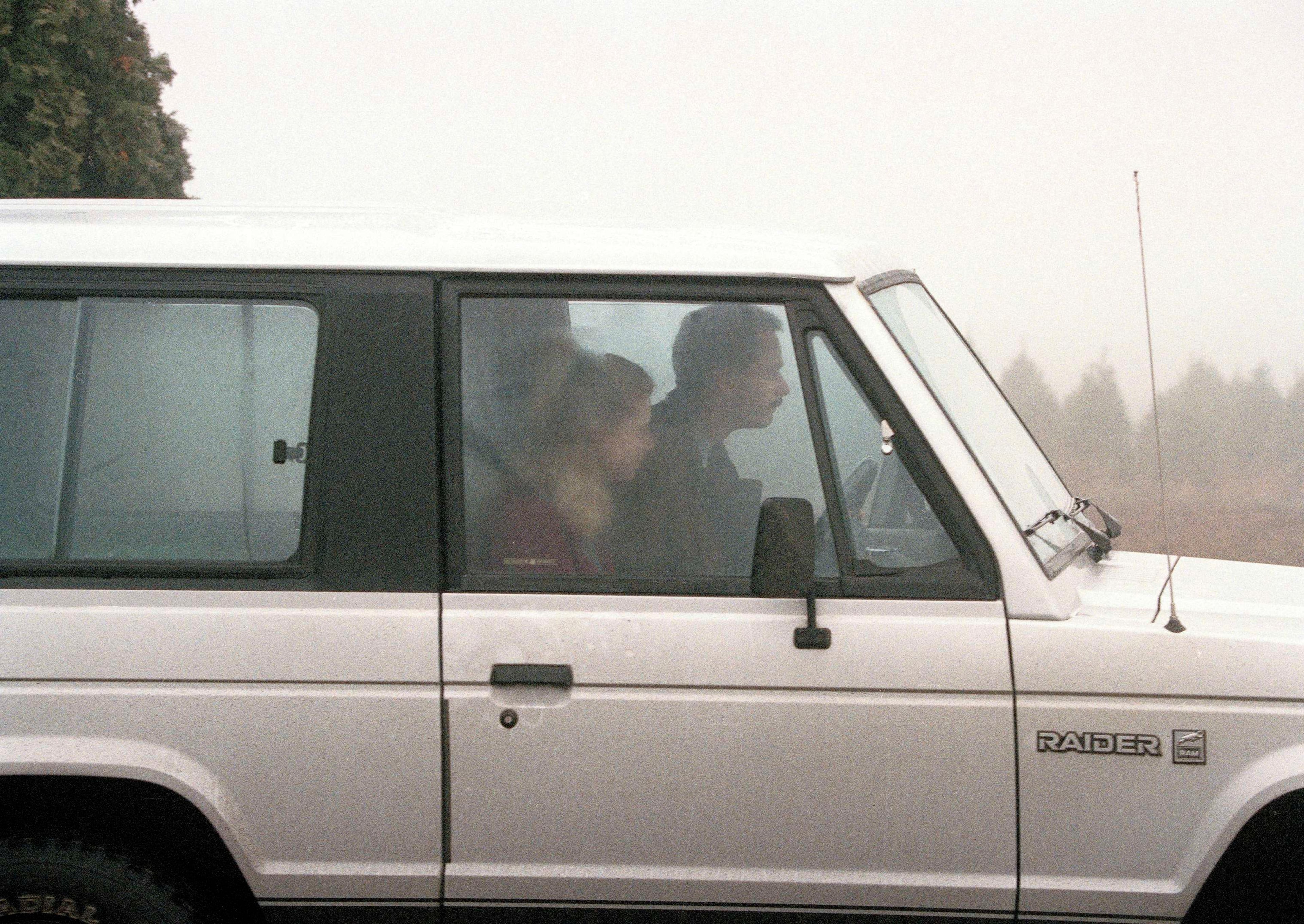 Figure skater Tonya Harding and her ex-husband Jeff Gillooly drive away from their home in Beaver Creek, Ore., Jan. 14, 1994. Three men, including Harding's bodyguard, Shawn Eric Eckardt, are in police custody in connection with the plot to injure Harding's figure skating rival Nancy Kerrigan. (AP Photo/Brian McLaughlin)