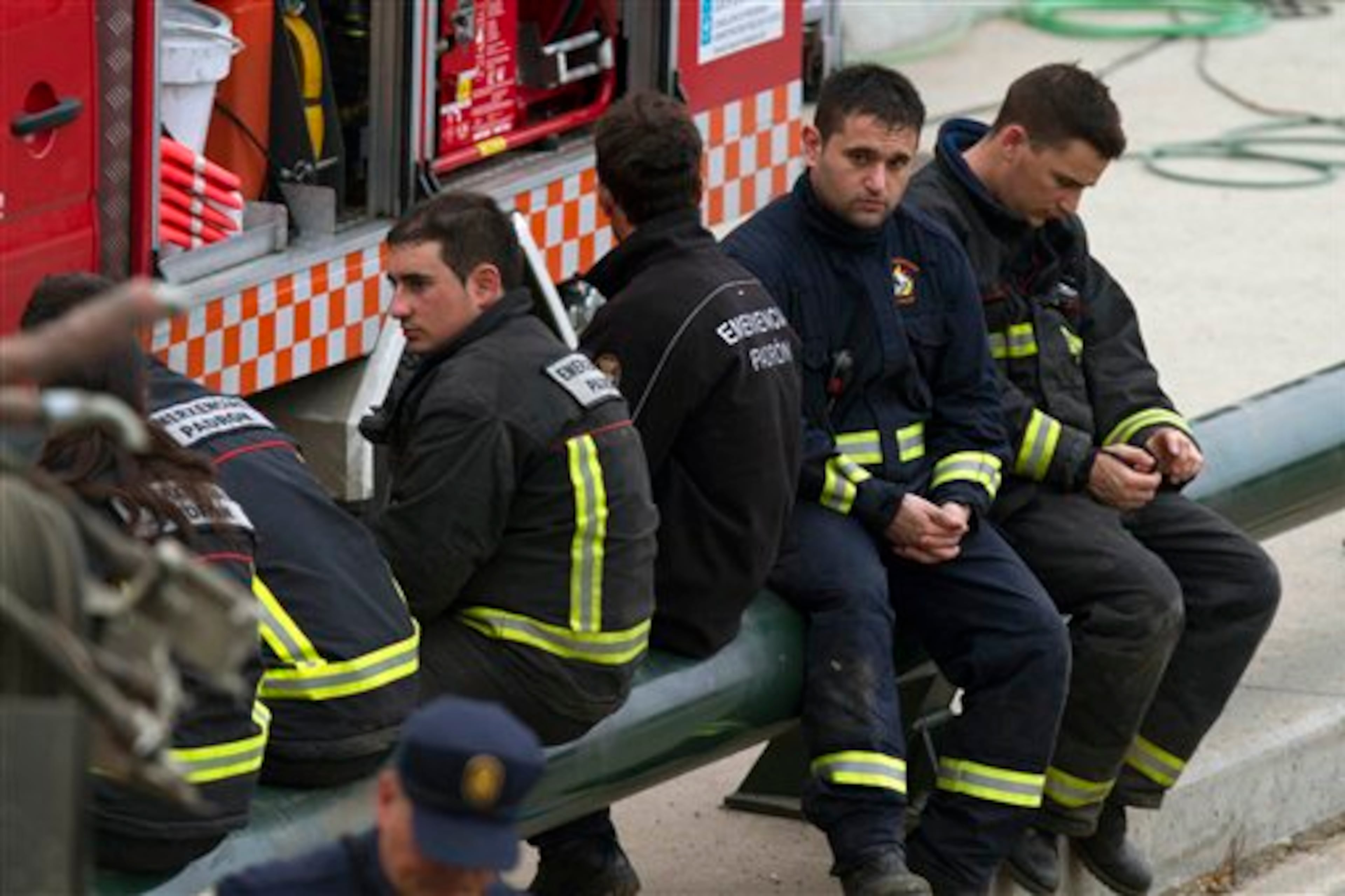 Emergency personnel take a break while working at the site of a train accident in Santiago de Compostela, Spain, on Thursday, July 25, 2013. The death toll in a passenger train crash in northwestern Spain rose to 77 on Thursday after the train jumped the tracks on a curvy stretch just before arriving in the northwestern shrine city of Santiago de Compostela, a judicial official said. (AP Photo/Lalo Villar)