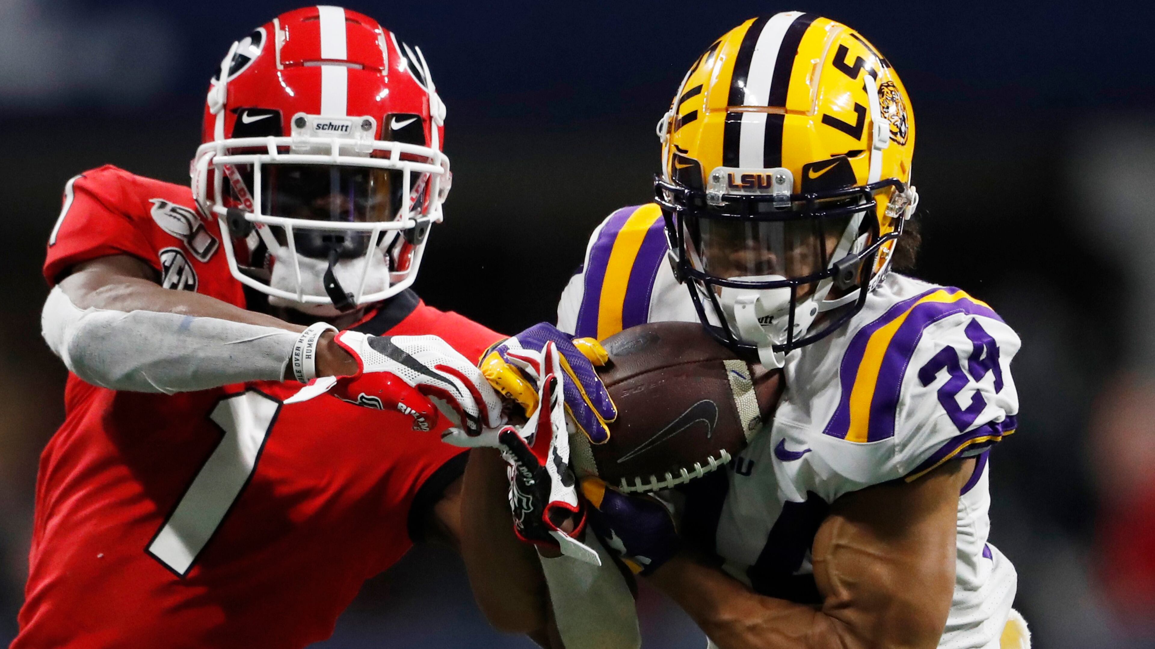 FILE - In this Dec. 7, 2019, file photo, LSU cornerback Derek Stingley Jr. (24) intercepts the ball from Georgia wide receiver George Pickens (1) during the second half of the Southeastern Conference championship NCAA college football game in Atlanta. Southeastern Conference schools will be able to bring football and basketball players back to campus for voluntary activities starting June 8 at the discretion of each university. The SEC’s announcement Friday, May 22, 2020, is the latest sign of encouragement that a college football season in at least some form can go on this fall.(AP Photo/John Bazemore, File)