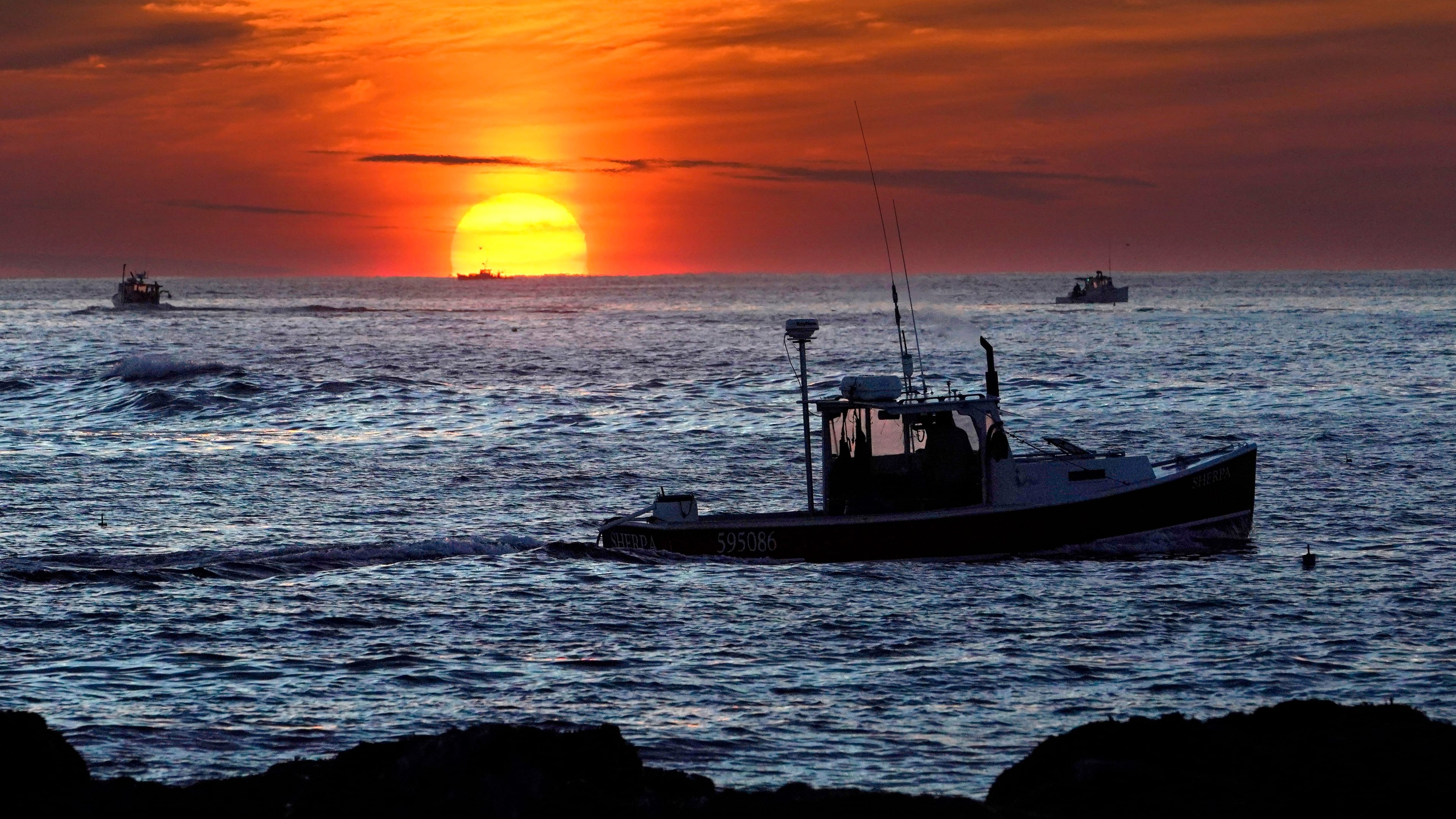 FILE - Lobster fishermen work at sunrise, Sept. 8, 2022, off Kennebunkport, Maine. (AP Photo/Robert F. Bukaty, File)