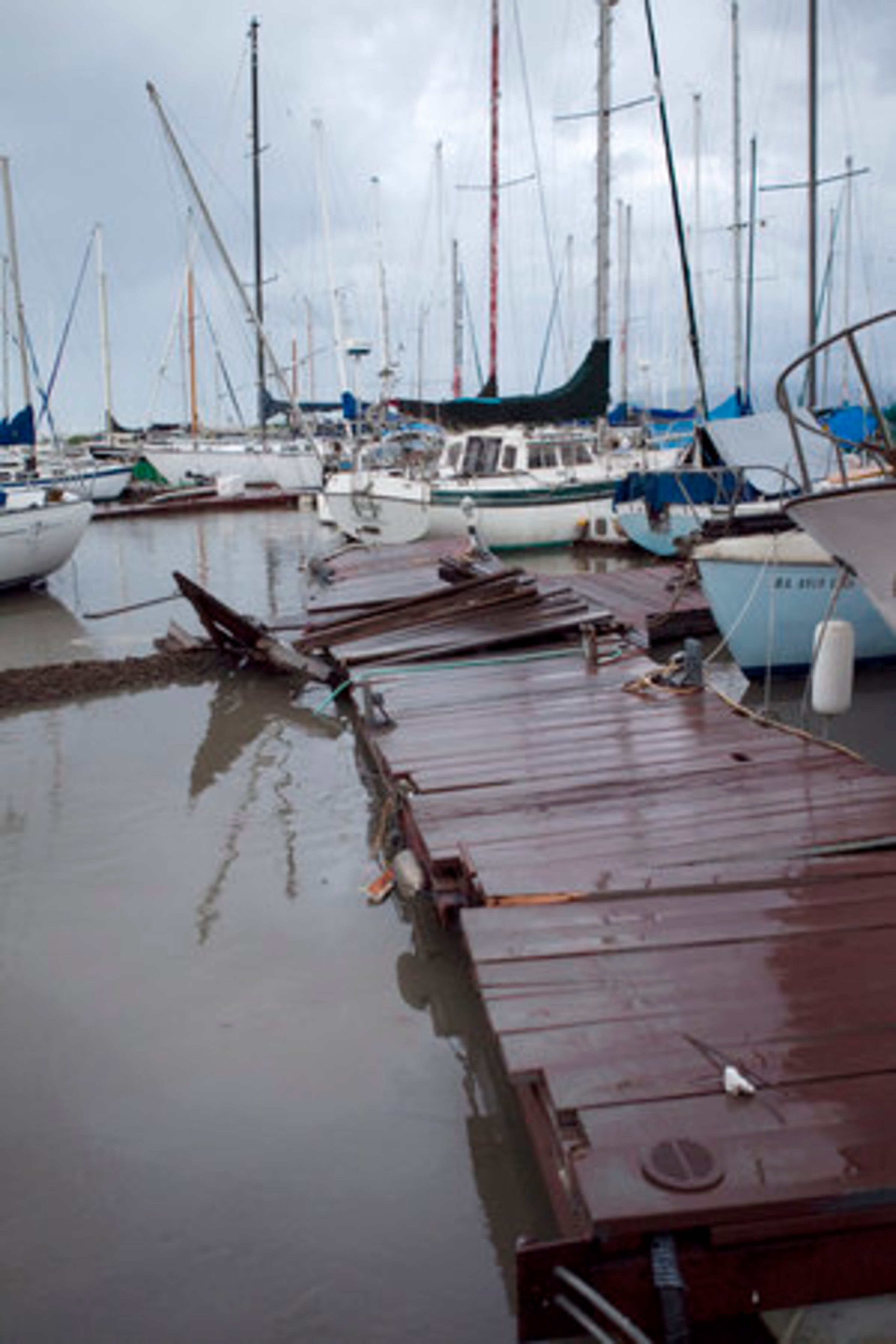 A tsunami generated by a massive earthquake in Japan hit Oahu, causing damage around the island, including this sailing club pier and moored boats at the site.