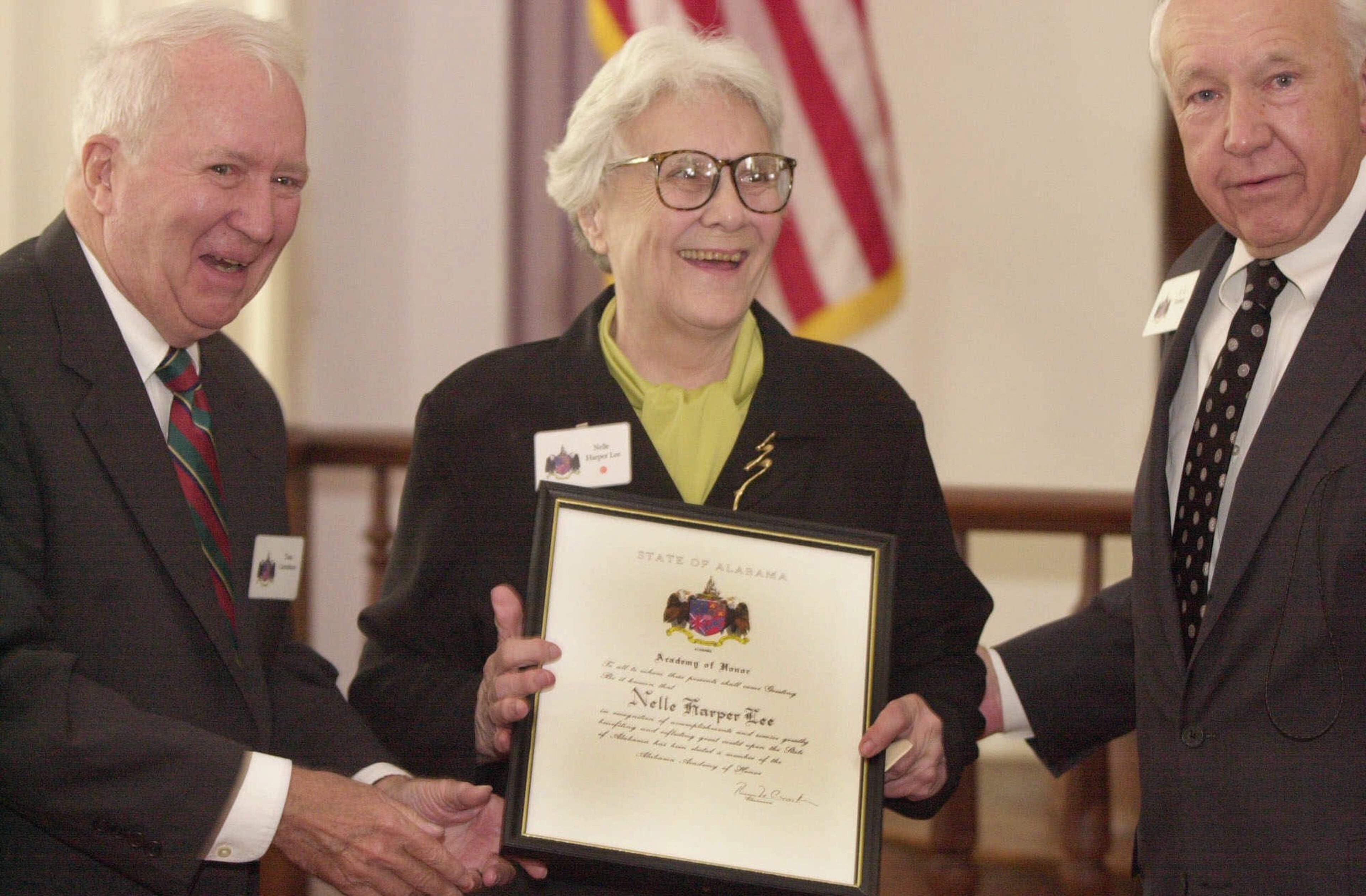 Acclaimed novelist Harper Lee is inducted into the Alabama Academy of Honor with four others in a ceremony Monday, Aug. 27, 2001, in the Alabama State Capitol House chambers in Montgomery, Ala. An Alabama native, Lee is best know for her novel "To Kill a Mockingbird." Presenting her the award is Alabama Academy of Honor member Thomas N. Carruthers, left, and executive committee member C. C. "Bo" Torbert, Jr. (AP Photo/The Birmingham News, Hal Yeager)