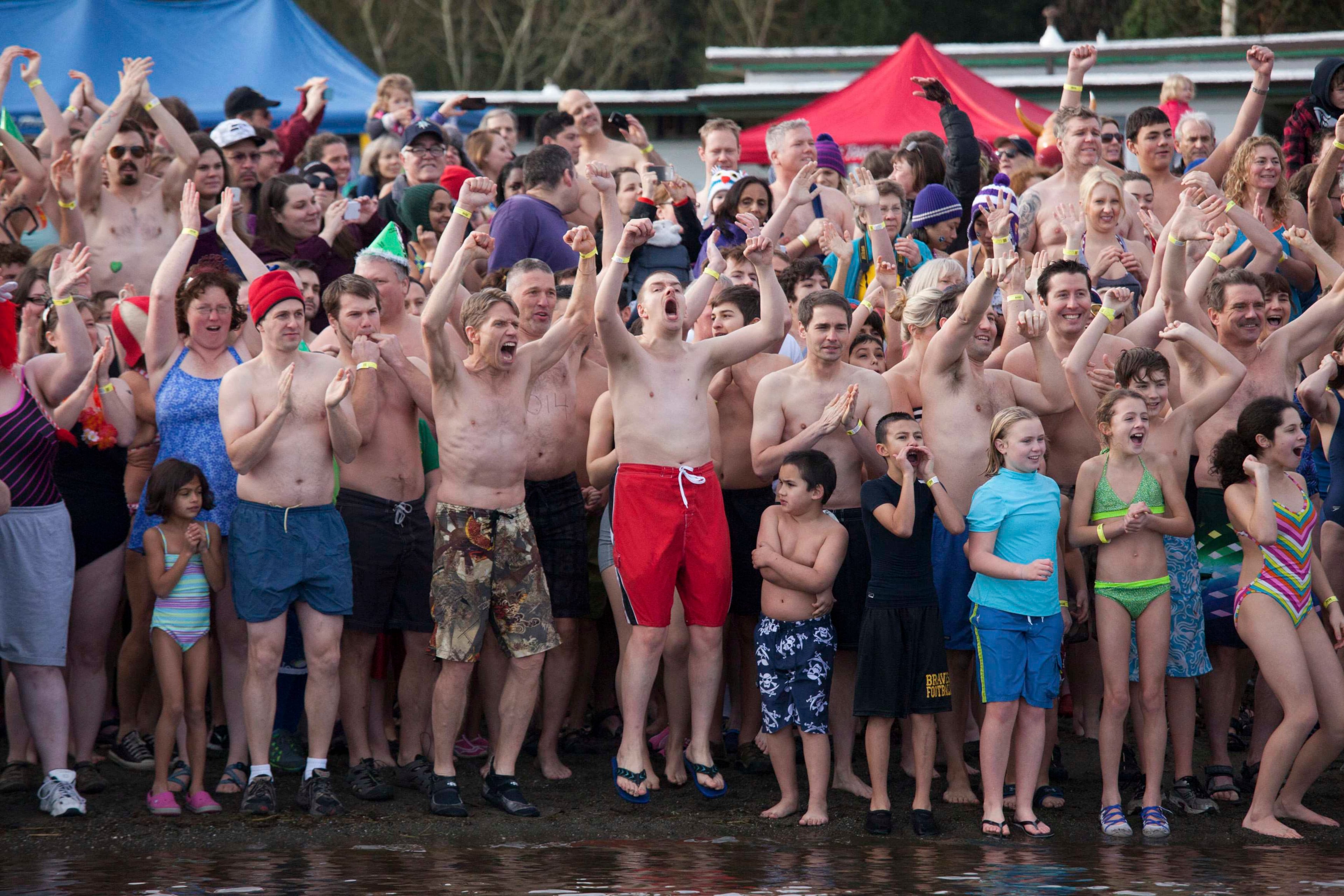 Participants cheer before entering Lake Washington during the 12th annual Polar Bear Plunge in Seattle, Washington January 1, 2014. Hundreds participated in the chilly New Year's Day tradition, organized by Seattle Parks and Recreation and held at Matthews Beach. REUTERS/David Ryder