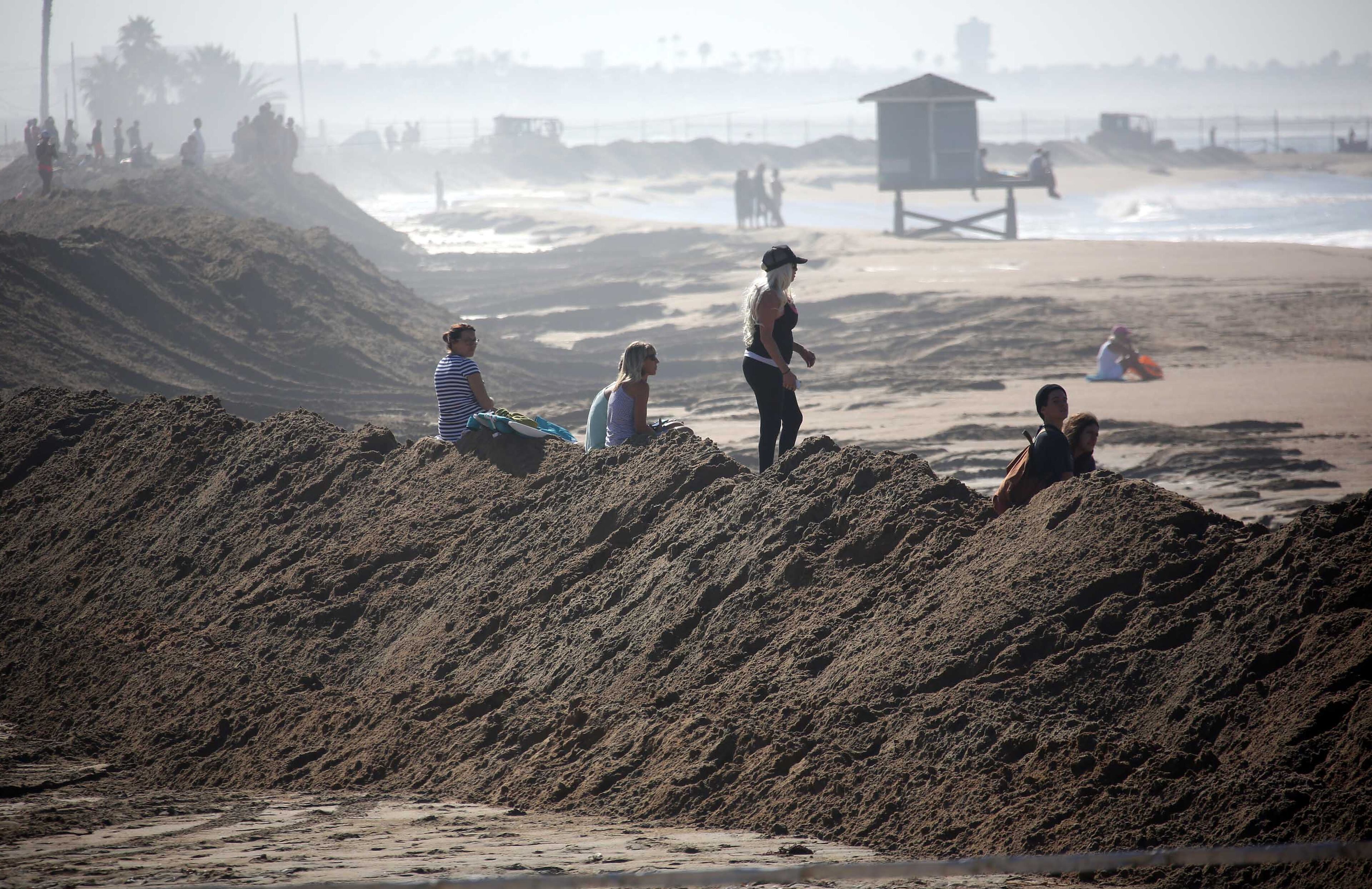 Onlookers standing on a sand berm watch as big waves come into shore from Hurricane Marie in Seal Beach, Calif. on Wednesday, August 27, 2014. The National Weather Service said beaches stretching 100 miles up the Southern California coast would see large waves and rip currents. Swimmers and surfers were urged to be aware of the dangerous conditions. (AP Photo/ Nick Ut )