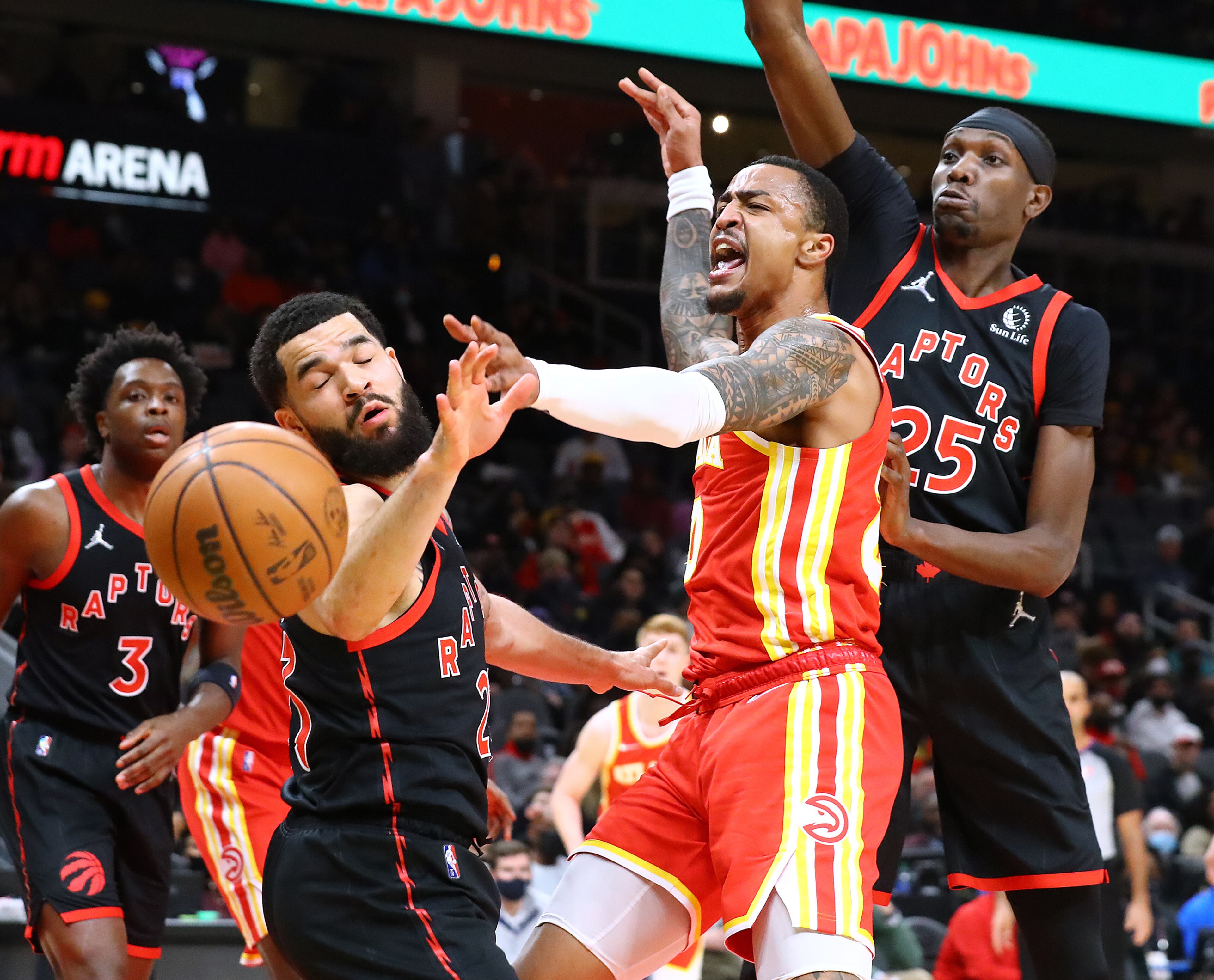 013122 Atlanta: Atlanta Hawks forward John Collins battles Toronto Raptors defenders Fred VanVleet (left) and Chris Boucher for a rebound under the basket in an NBA basketball game on Monday, Jan. 31, 2022, in Atlanta. “Curtis Compton / Curtis.Compton@ajc.com”`