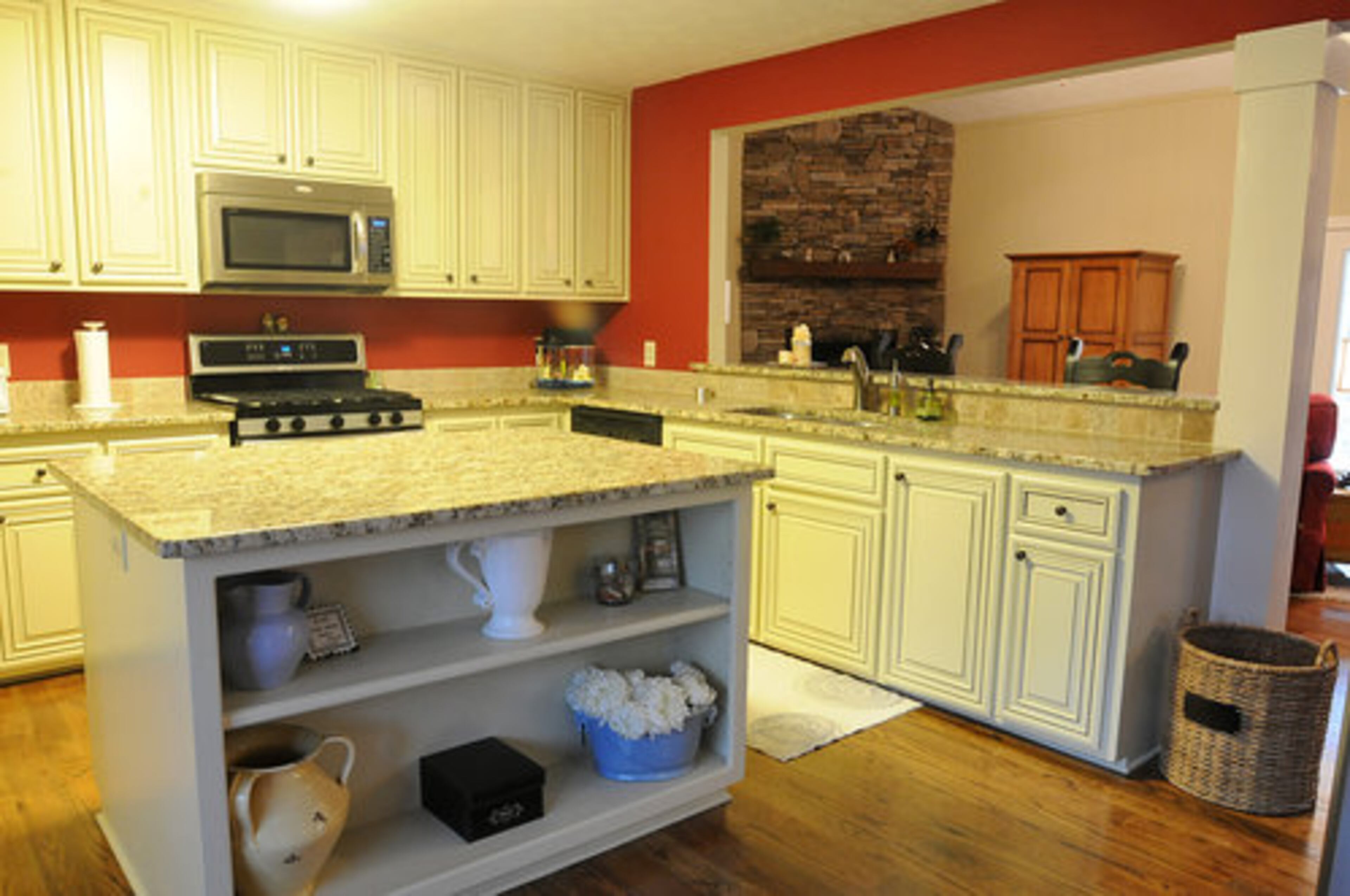 Kitchen)The kitchen was completely renovated. A center Island was completely replaced, and cabinets were refaced, added new granite counter tops, removed a 30 year old trash compactor and replaced it with a cabinet trash can pull out. " We chose glazed cream cabinets with dark accents cabinets to make the room bright without being white," Amanda said.