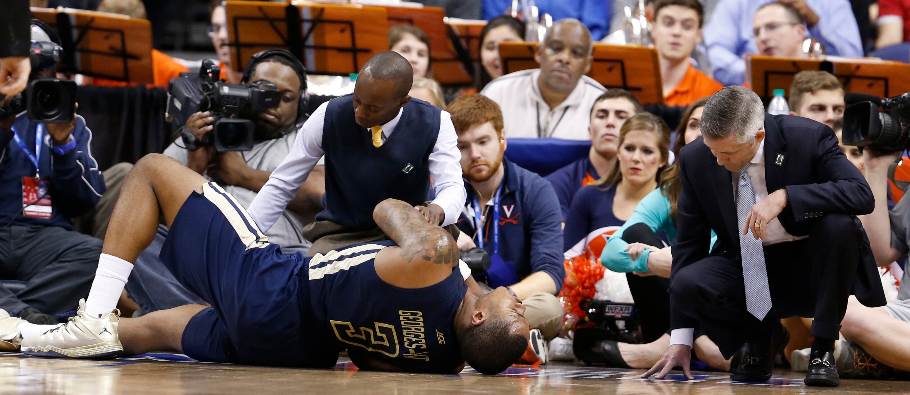 Georgia Tech coach Brian Gregory, right, looks over injured guard Marcus Georges-Hunt (3) along with a trainer during the second half of an NCAA college basketball game in the Atlantic Coast Conference tournament in Washington on Thursday, March 10, 2016. Virginia defeated Georgia Tech 72-52. (AP Photo/Steve Helber)