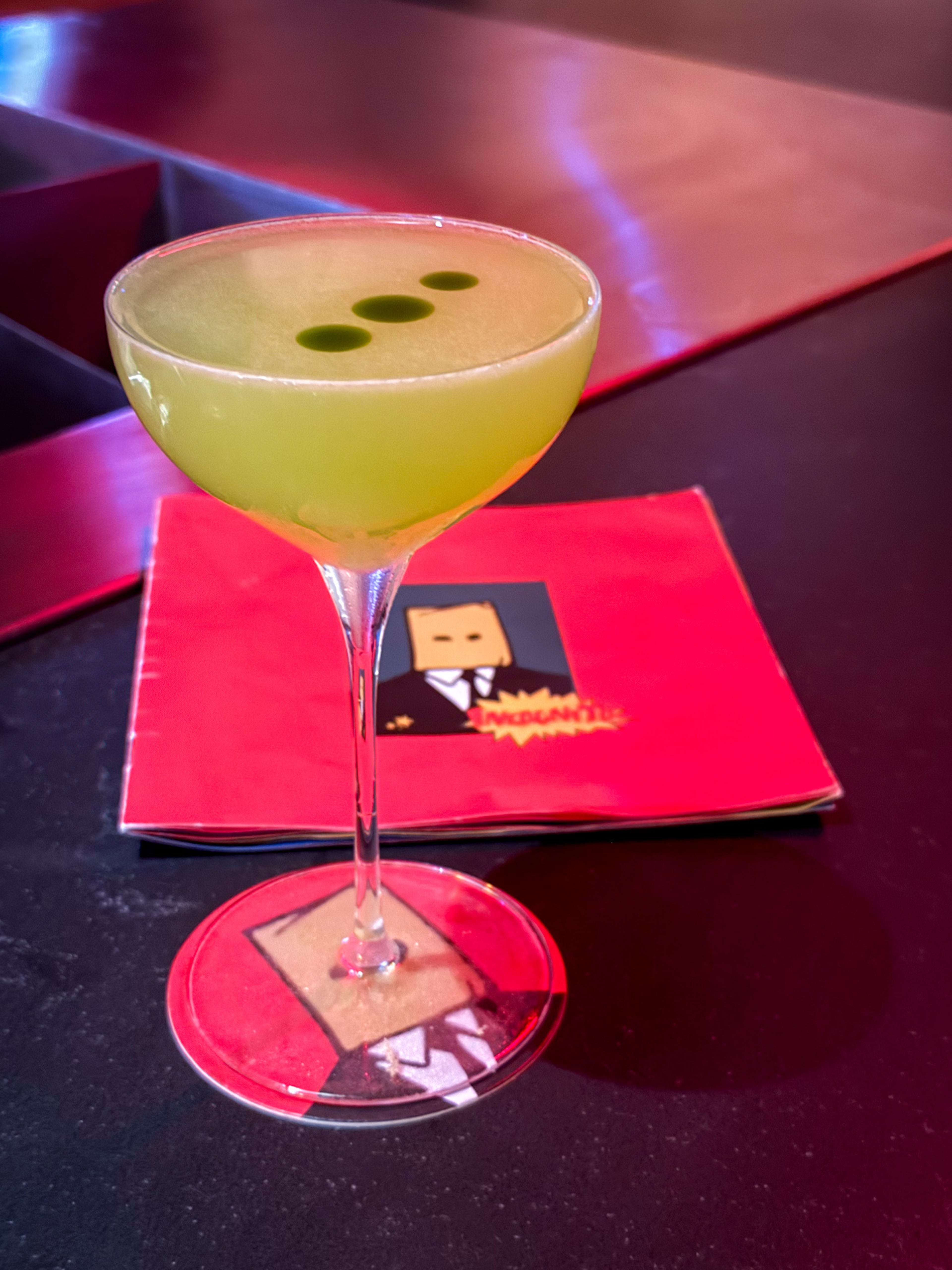 The gimlet at Incognito is topped with drops of fragrant basil oil. (Henri Hollis/AJC)