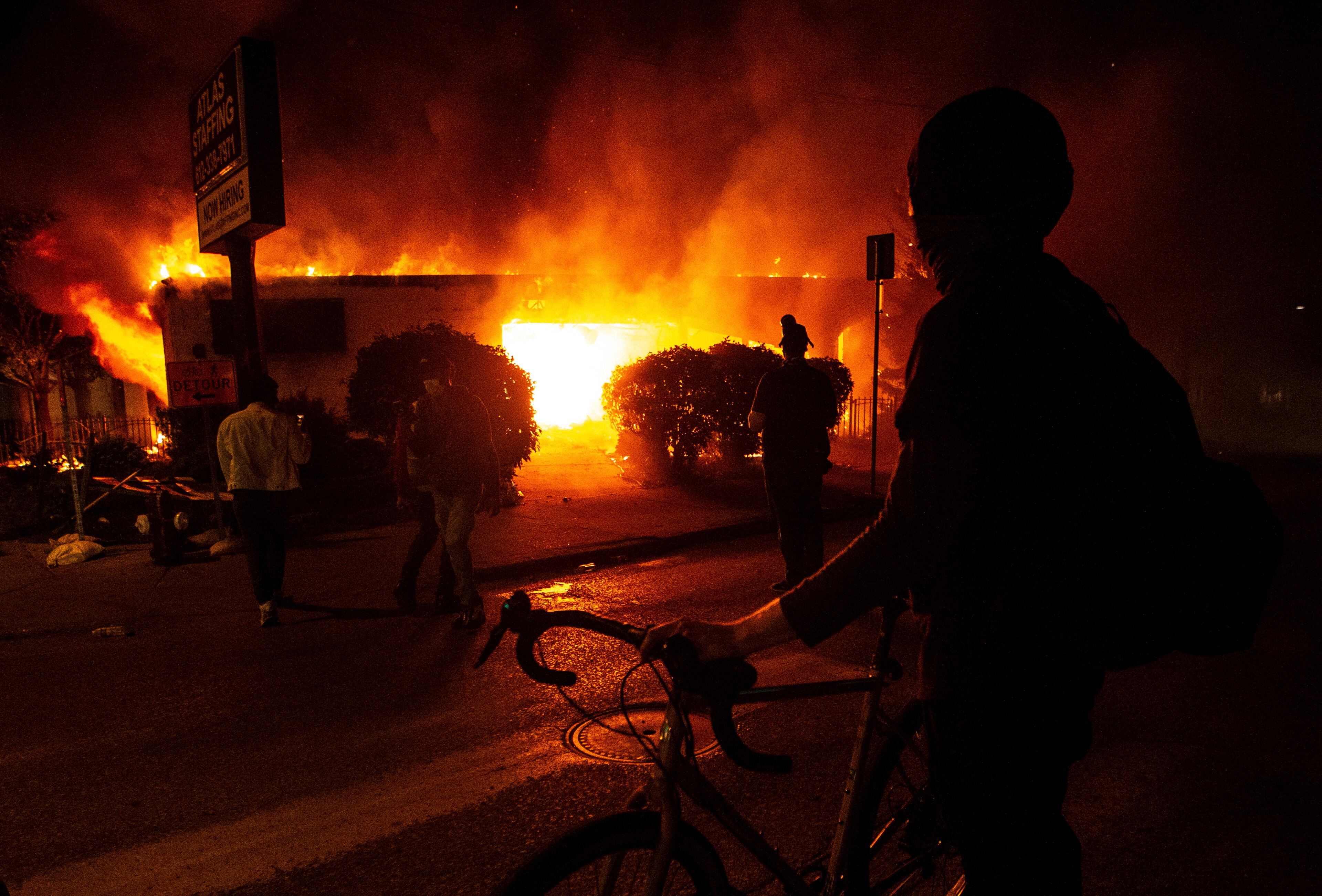 A protester looks at a burning building early Saturday in Minneapolis.