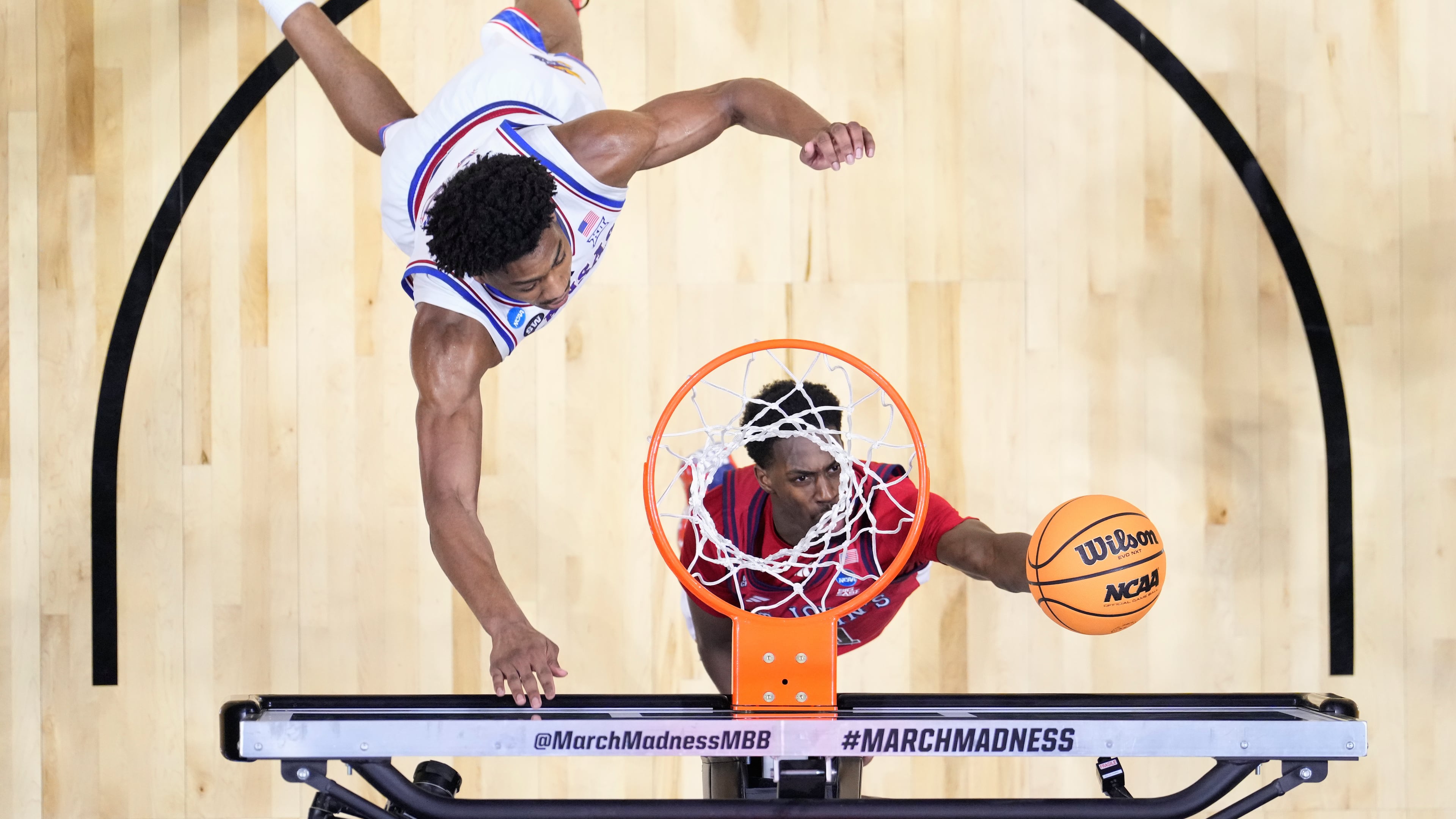 St. John's guard Ian Jackson (11) shoots around Kansas forward Bryson Tiller (15) during a game in the second round of the NCAA college basketball tournament Sunday, March 22, 2026, in San Diego. (AP Photo/Mark J. Terrill)