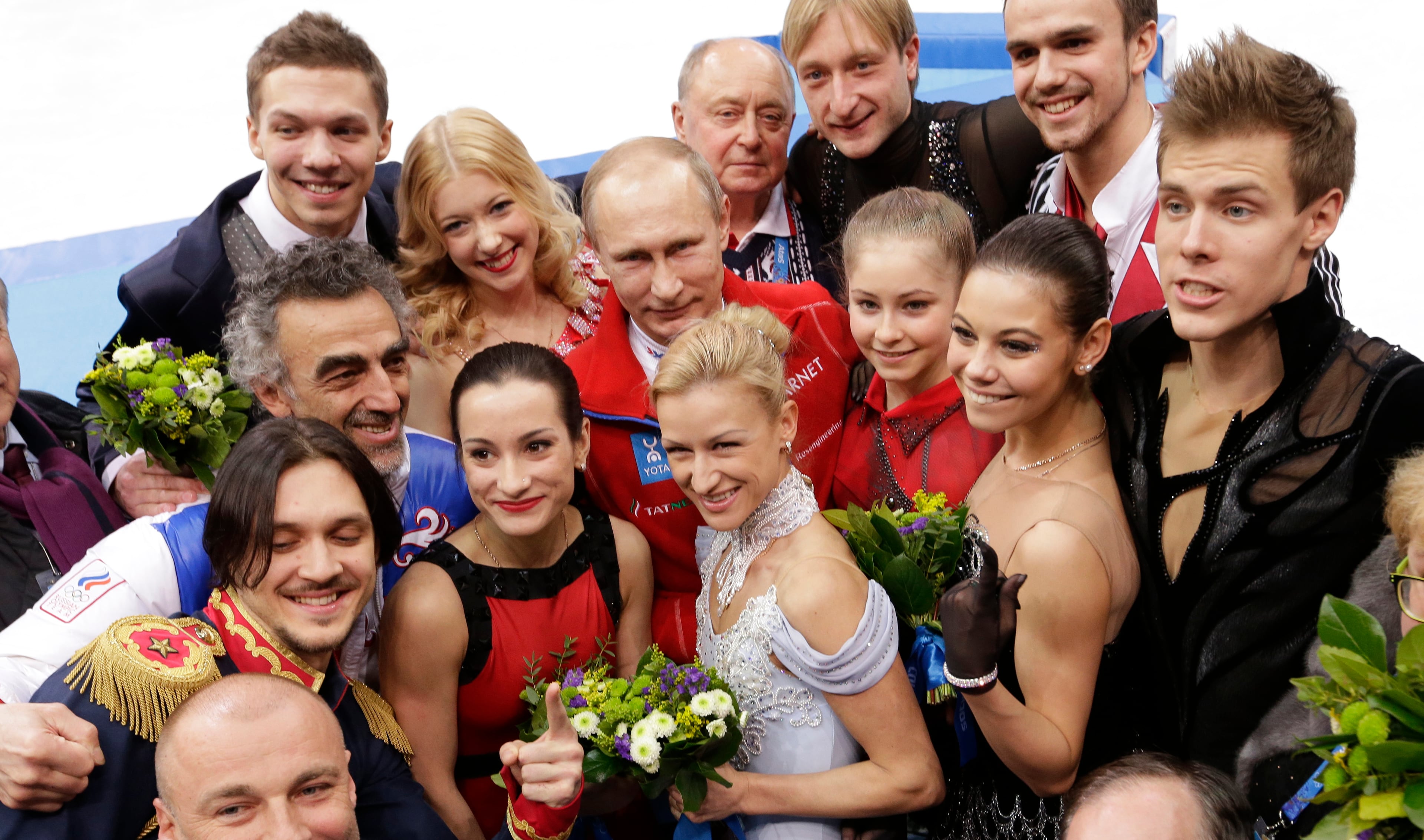 Russian President Vladimir Putin, centre back, poses for a photograph with the Russian team after they placed first in the team figure skating competition at the Iceberg Skating Palace during the 2014 Winter Olympics, Sunday, Feb. 9, 2014, in Sochi, Russia. (AP Photo/David J. Phillip )