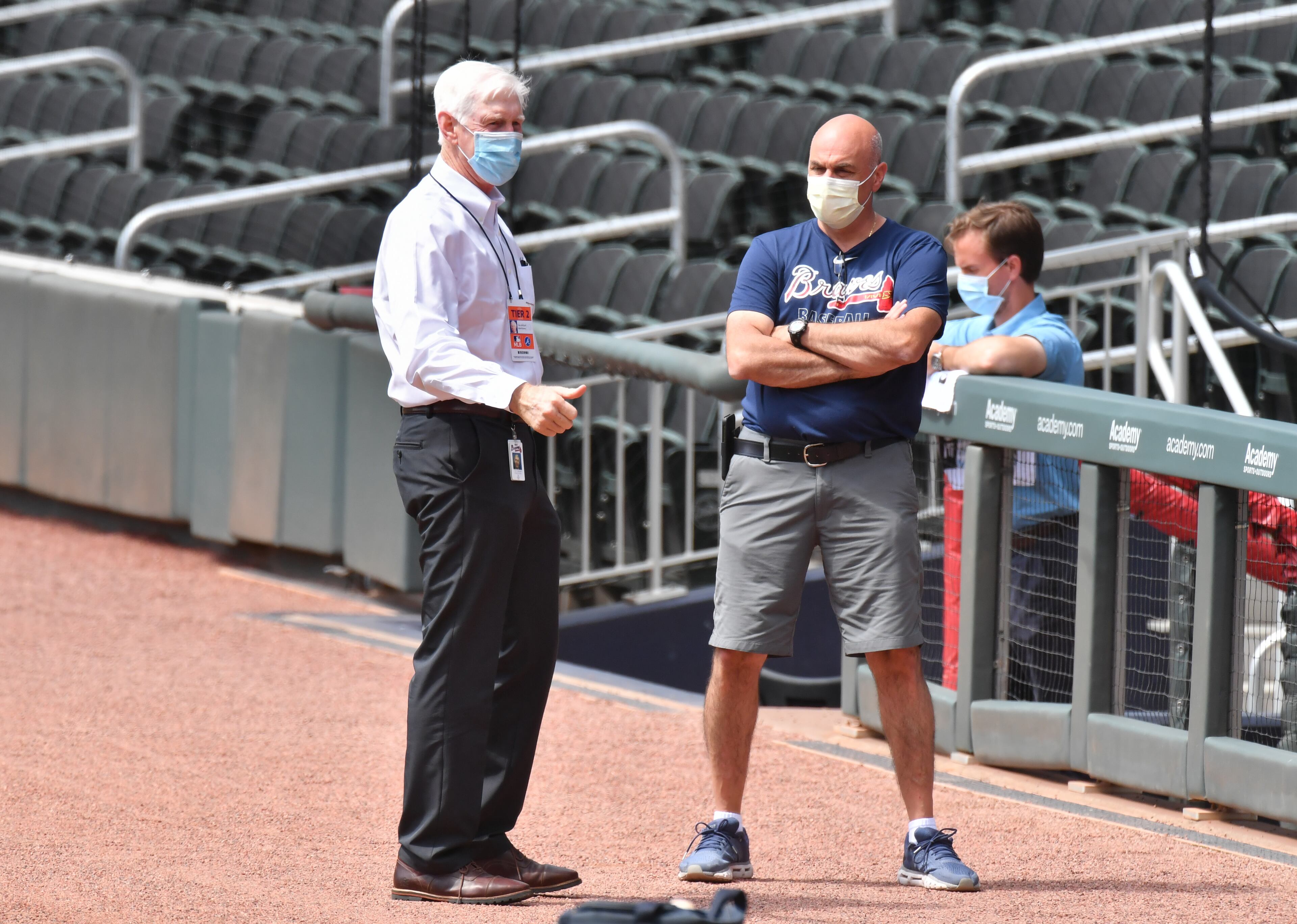 Braves chairman Terry McGuirk (left) talks with trainer George Poulis. (Hyosub Shin / Hyosub.Shin@ajc.com)