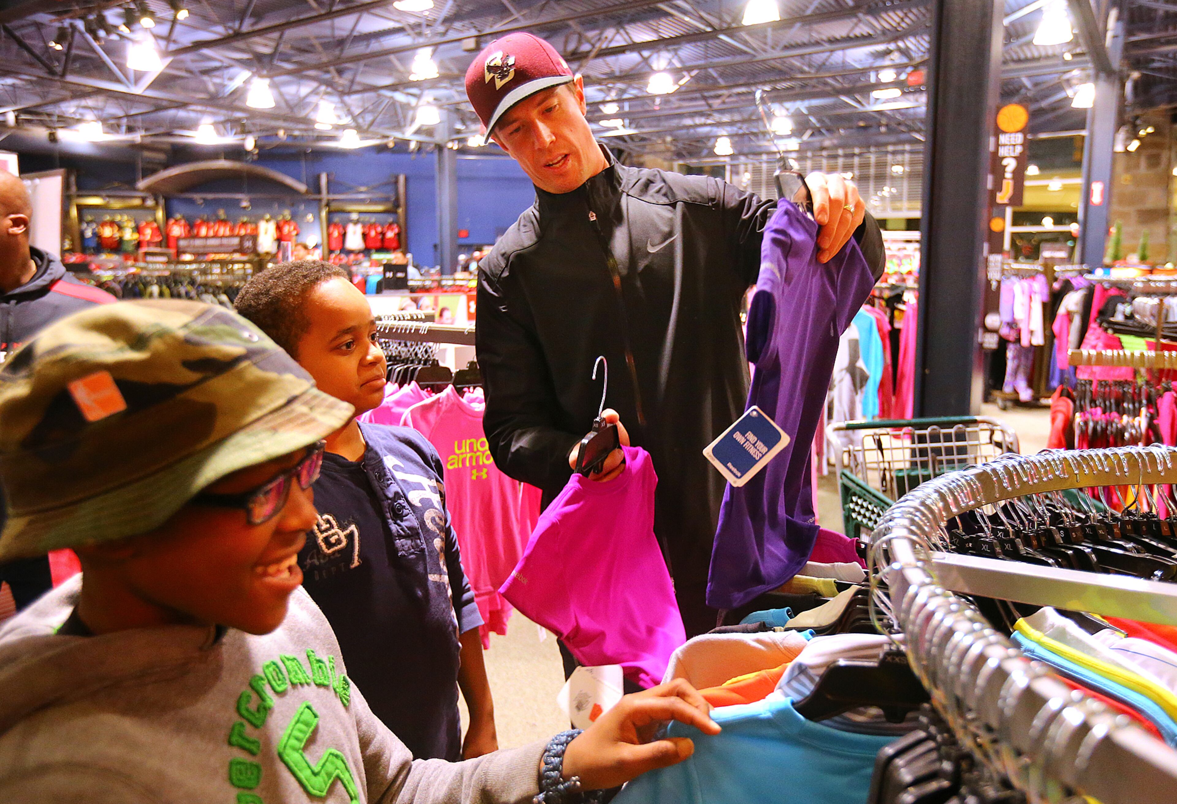 Before picking out gifts for themselves Akhir Carswell ( from left), 11, and Rashan Warren, 12, pick out a gift for their sisters with the help of quarterback Matt Ryan during thier Christmas shopping spree at Dick's Sporting Goods on Tuesday, Dec. 16, 2014, in Duluth. Ryan and the Falcon Rookie Club sponsored by UnitedHealthcare of Georgia, hosted "Shop with a Pro" offering children the opportunity to bond while shopping with professional athletes during the holidays. CURTIS COMPTON / CCOMPTON@AJC.COM