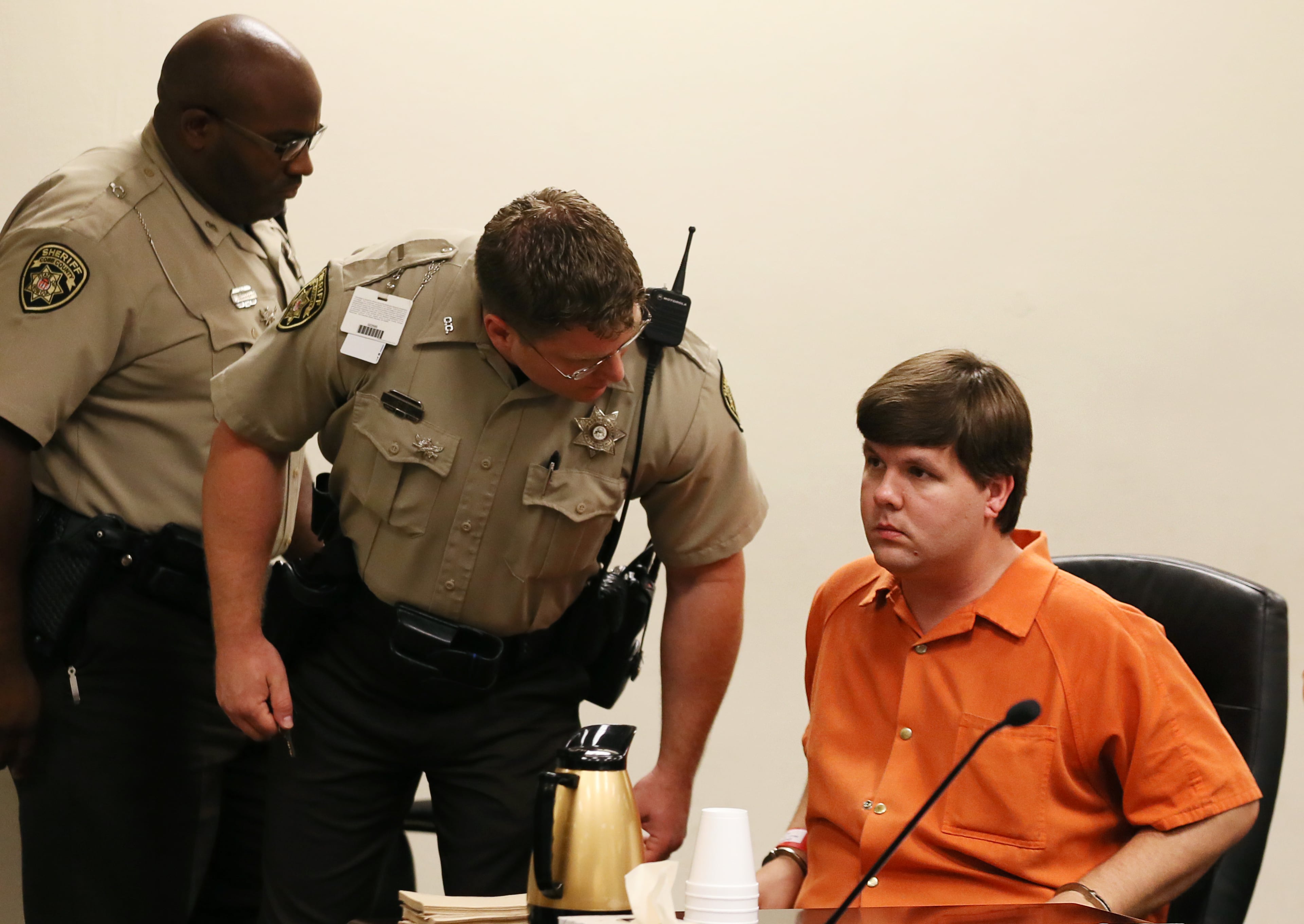 A Cobb County Sheriff's deputy talks to Justin Ross Harris, right, the father of a toddler who died after police say he was left in a hot car for about seven hours, as he appears for his bond hearing in Cobb County Magistrate Court, Thursday, July 3, 2014, in Marietta, Ga. (AP Photo/Marietta Daily Journal, Kelly J. Huff, Pool)