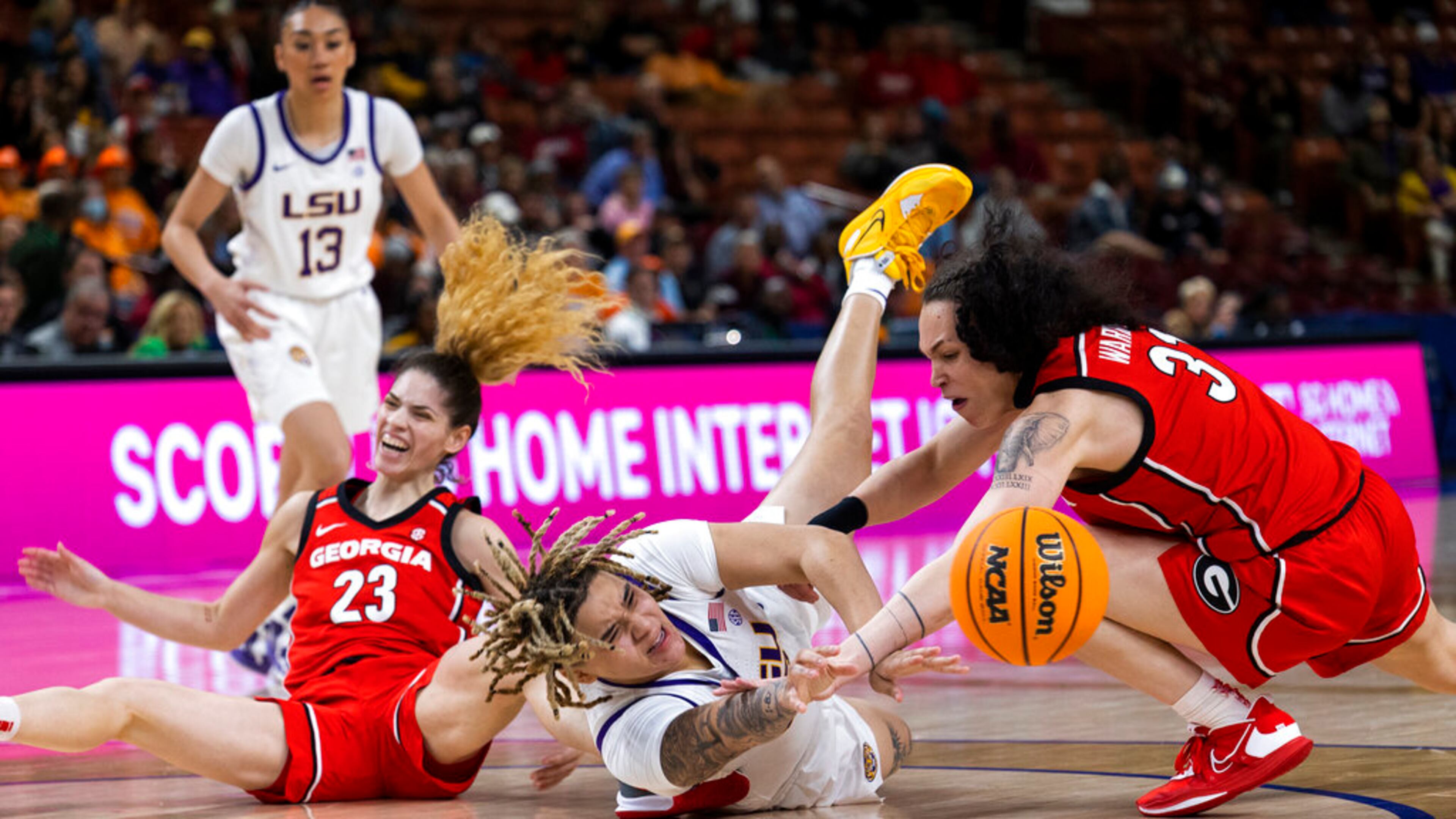 LSU's Kateri Poole, center, reaches for the ball between Georgia's Alisha Lewis (23) and Audrey Warren (31) in the first half of an NCAA college basketball game during the Southeastern Conference women's tournament in Greenville, S.C., Friday, March 3, 2023. (AP Photo/Mic Smith)