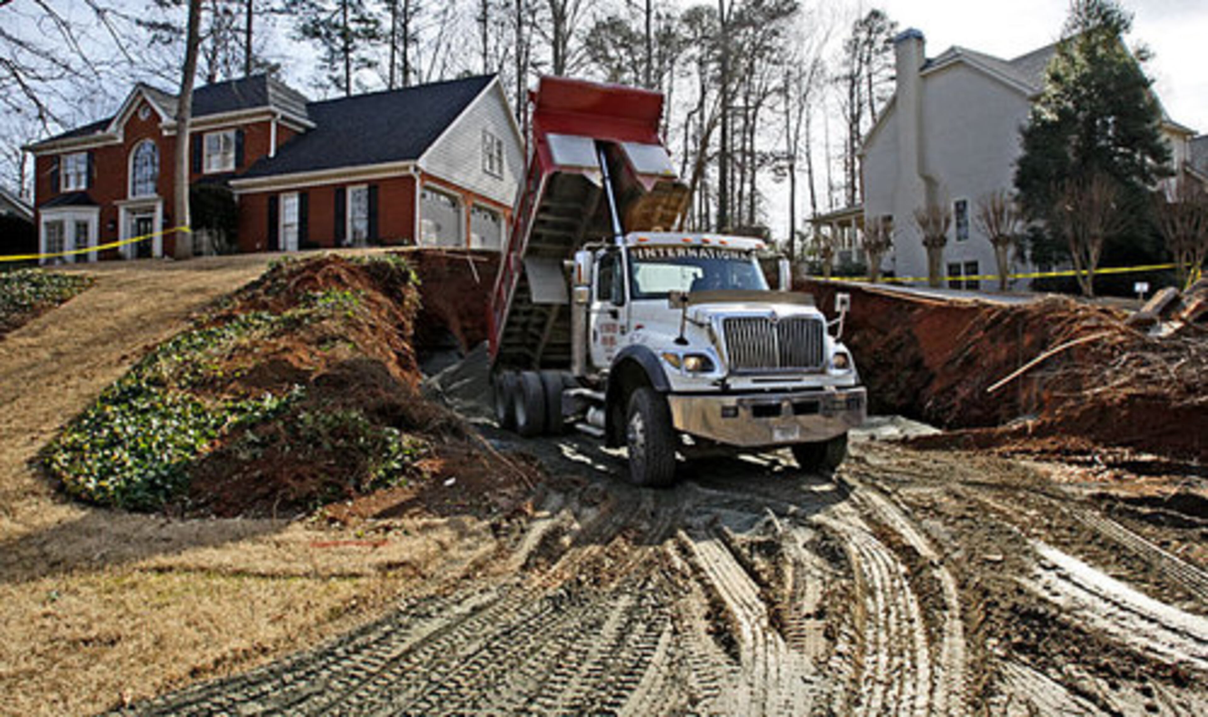 A steady stream of dump trucks ferried a sand-cement mixture from a Kennesaw quarry to the home in the 1100 block of Charlton Trace. Workers at the site estimated it would take 180 truckloads to fill in the hole, which developed earlier this week.
