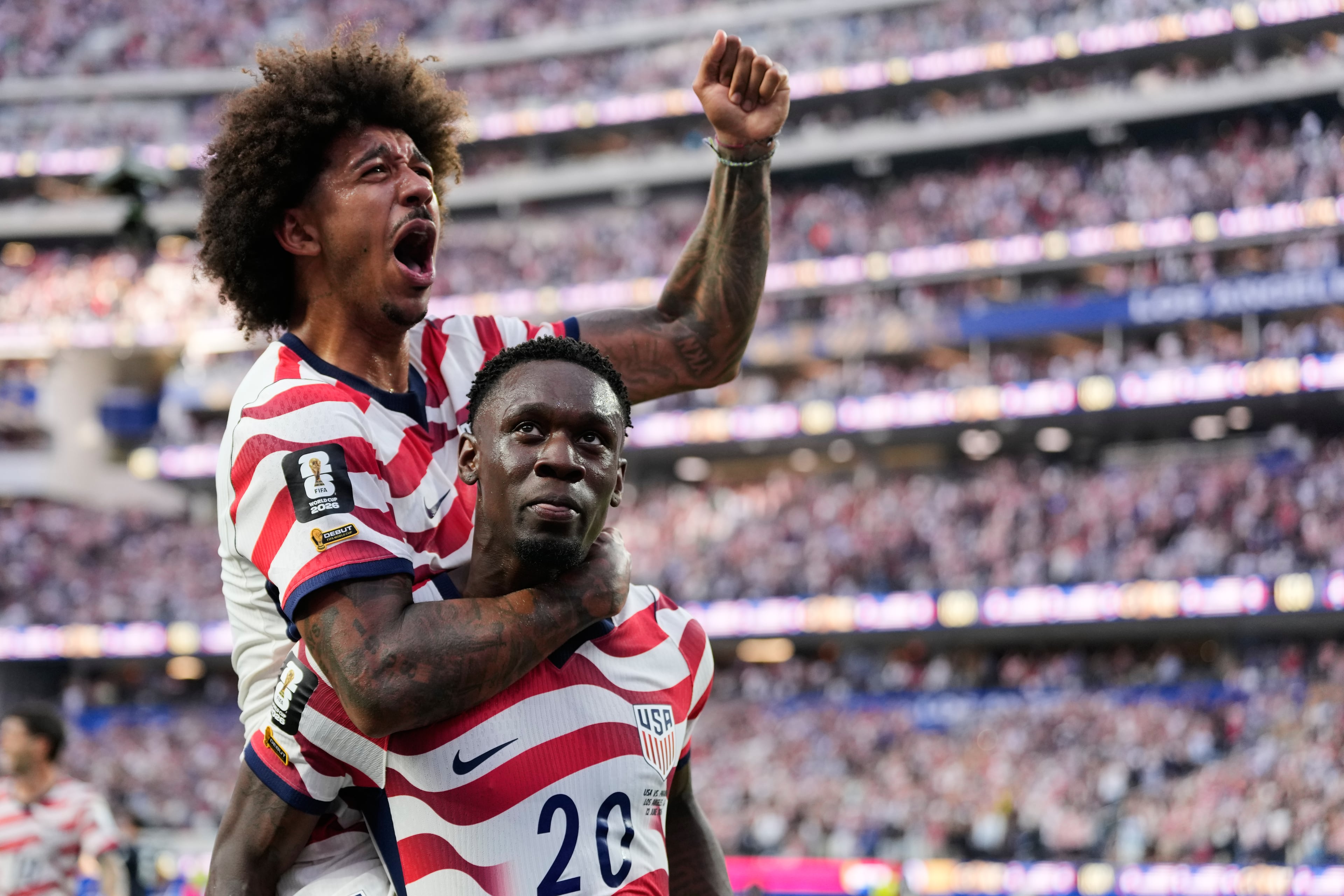Folarin Balogun gives teammate Chris Richards a celebratory piggyback ride after one of his two goals against Paraguay. (Andre Penner/AP)