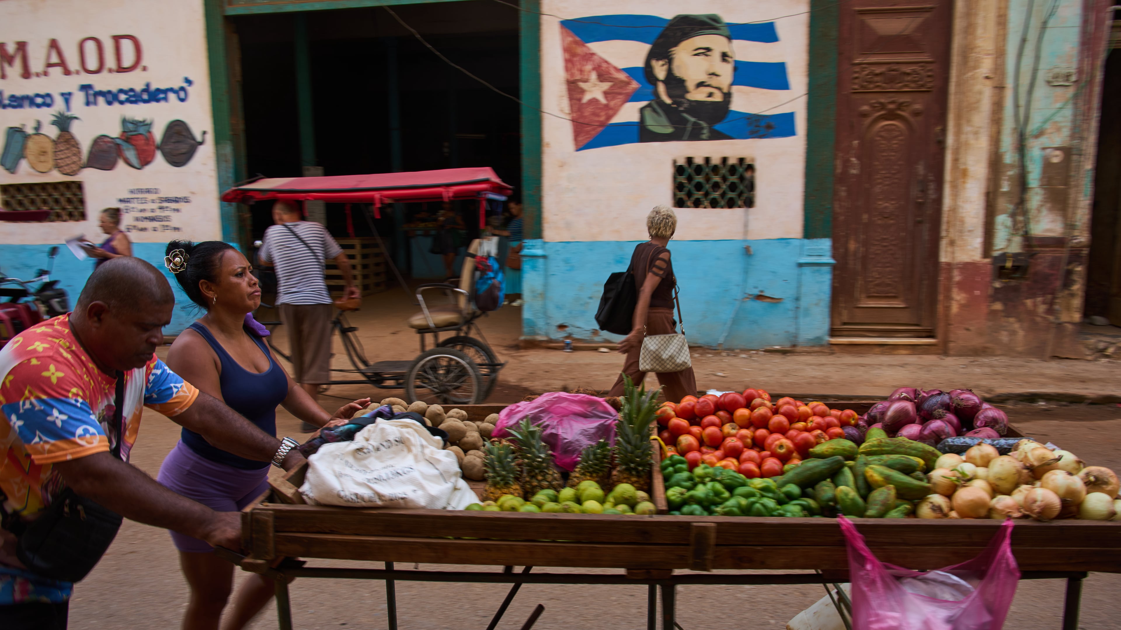 Street vendors push their cart of vegetables past a mural of Fidel Castro in Havana, Cuba, Wednesday, Aug. 12, 2026. (AP Photo/Ramon Espinosa)