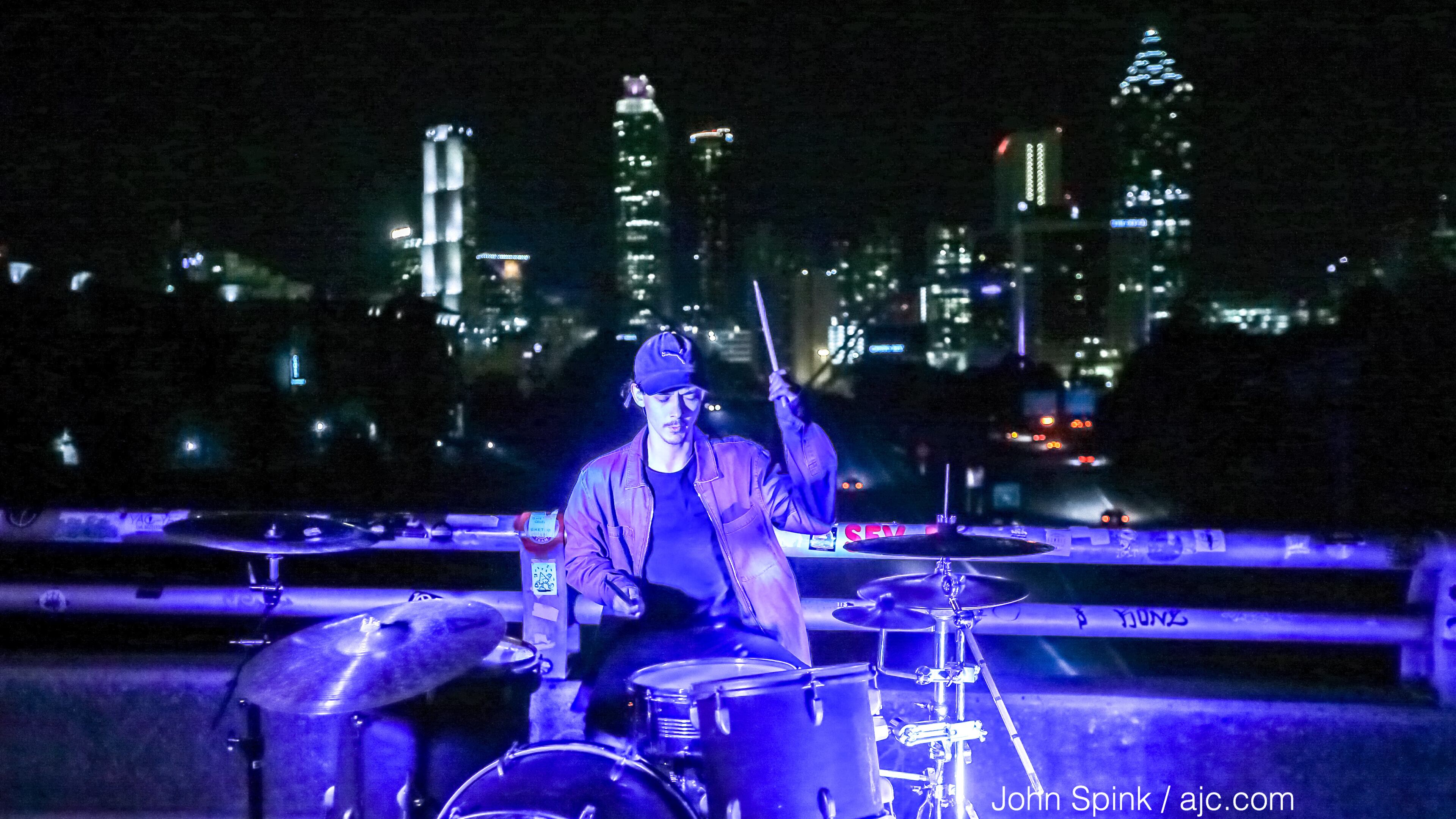Damien Allen of Sleeping Bear drumming through the morning rush hour on the Jackson Street Bridge earlier this week.