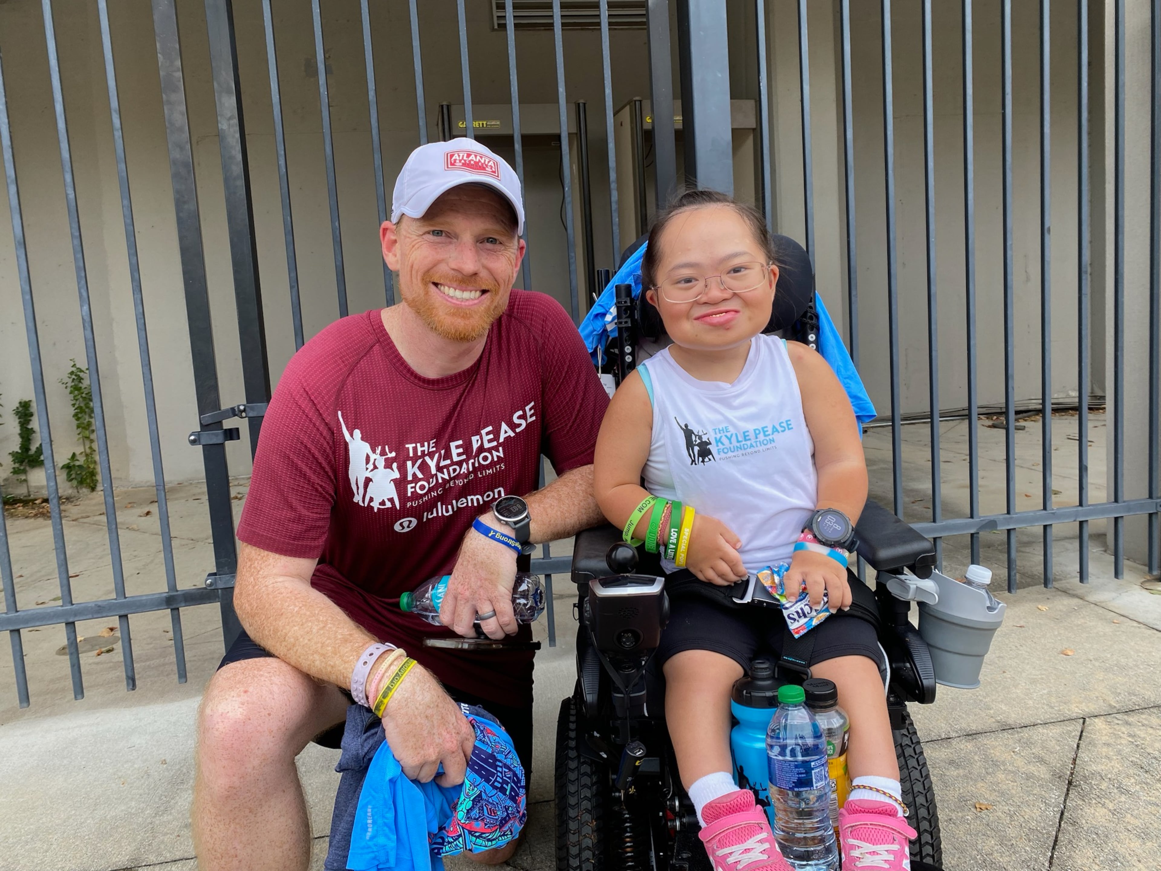 Robert Buckley, left, of Dunwoody, was the running partner for Erika Northrop, 17, of Acworth, for the AJC Peachtree Road Race on July 4, 2024. Buckley and Northrop competed in the push-assist division of the race. (Photo by Ken Sugiura/The Atlanta Journal-Constitution)