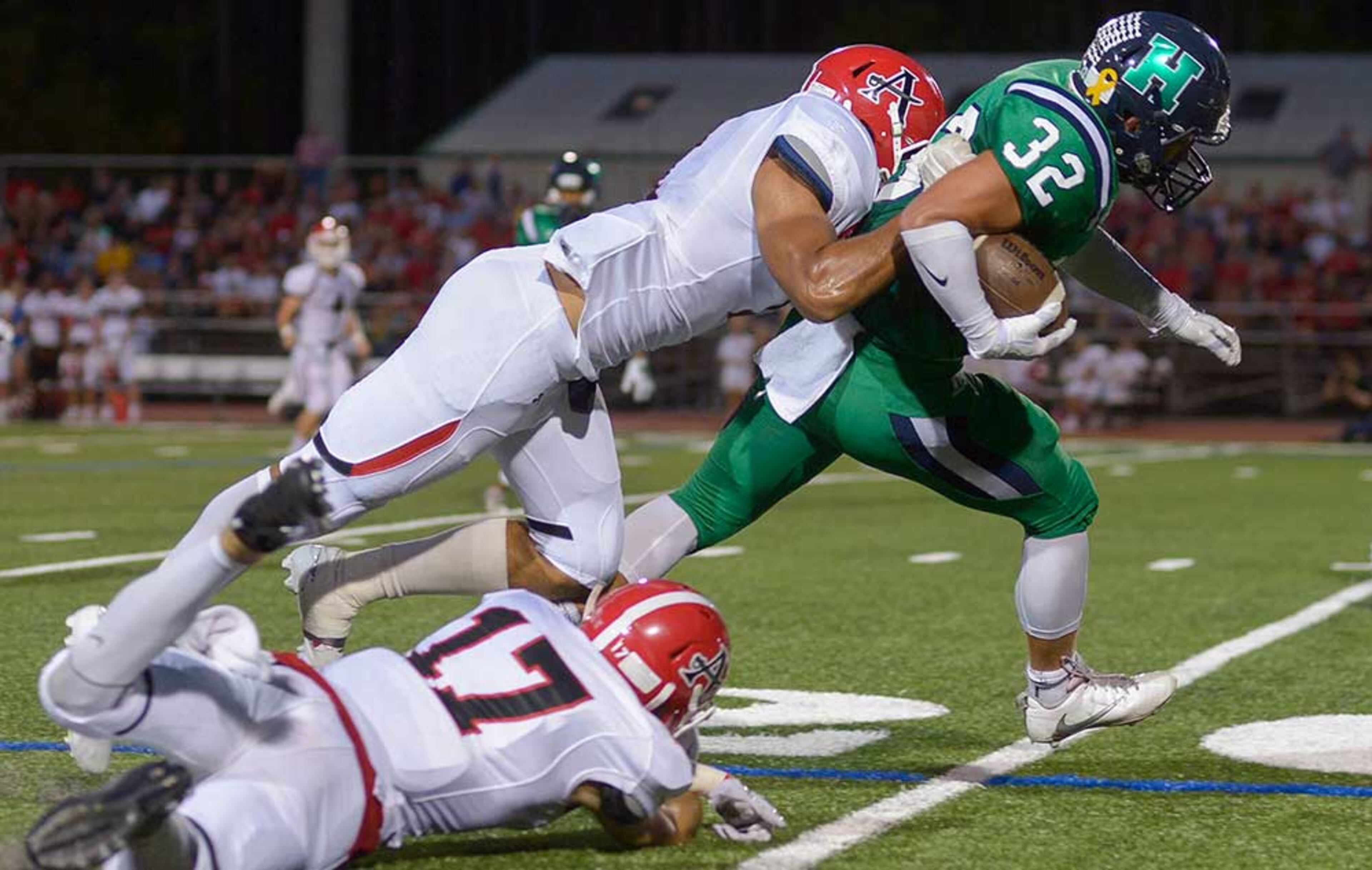 Allatoona senior OLB Michael Robison (1) and junior QB Cameron Carter (17) make a tackle on Harrison sophomore FB Cam Messina (32) during Friday's game.