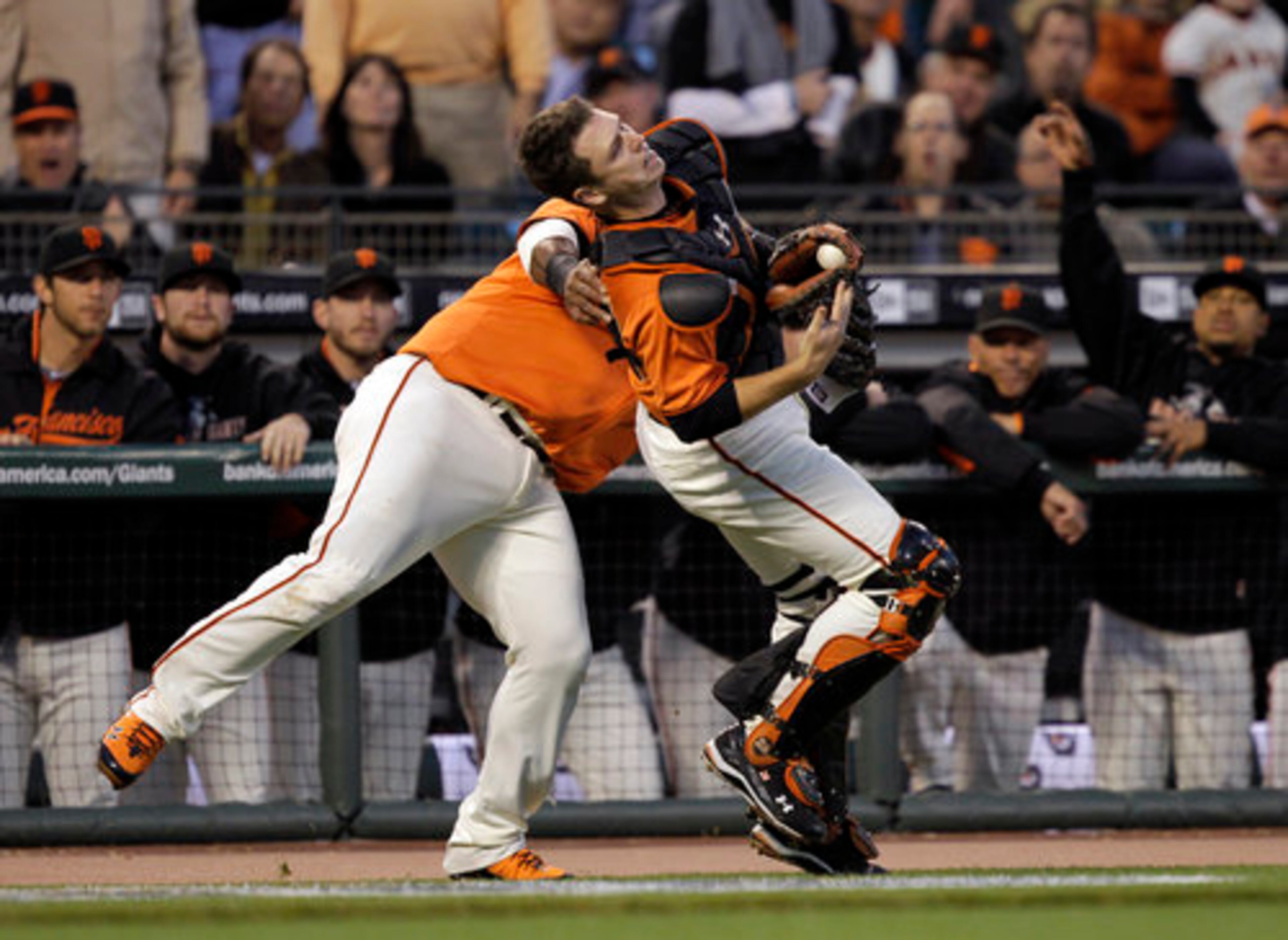 Giants catcher Buster Posey, right, collides with Pablo Sandoval while chasing and catching a pop foul ball hit by Atlanta Braves Jason Heyward in the first inning of Game 2 of the San Francisco Giants National League Division Series baseball game in San Francisco, Friday, Oct. 8, 2010.
