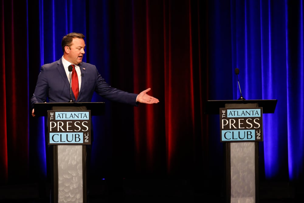 Lt. Gov. Burt Jones, a Republican candidate for governor, gestures to the empty podium at the Atlanta Press Club Loudermilk-Young Debate Series on Monday. His opponent, Rick Jackson, did not attend, citing a scheduling conflict. (Arvin Temkar/AJC)