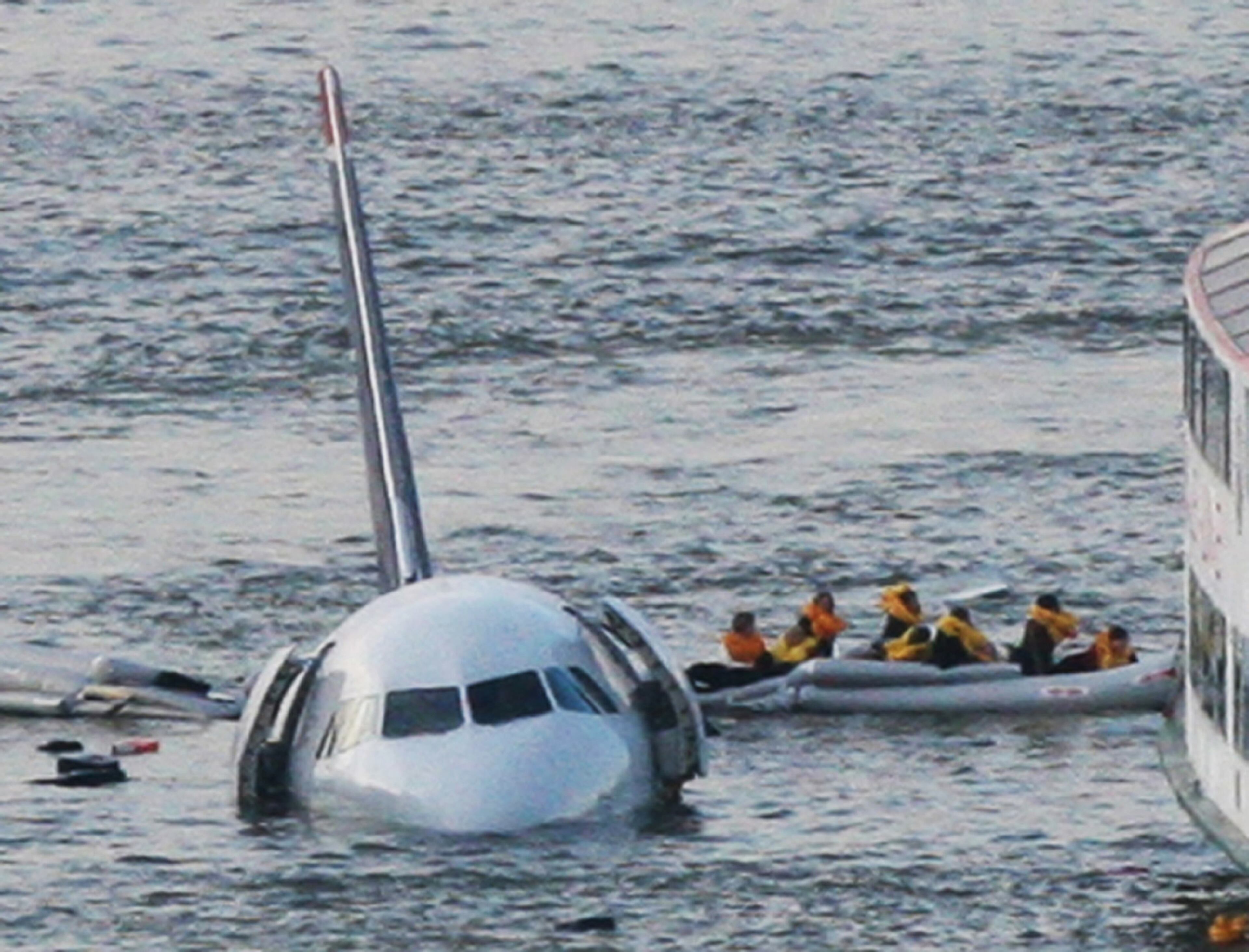In this Jan. 15, 2009 file photo, passengers in an inflatable raft move away from US Airways Flight 1549 that went down in the Hudson River in New York. Capt. Chesley "Sully" Sullenberger III, First Officer Jeff Skiles and some passengers who were on the plane on Wednesday, Jan. 15, 2014 joined some of the ferry crews who rescued them from the cold waters five years ago. (AP Photo/Bebeto Matthews, File)