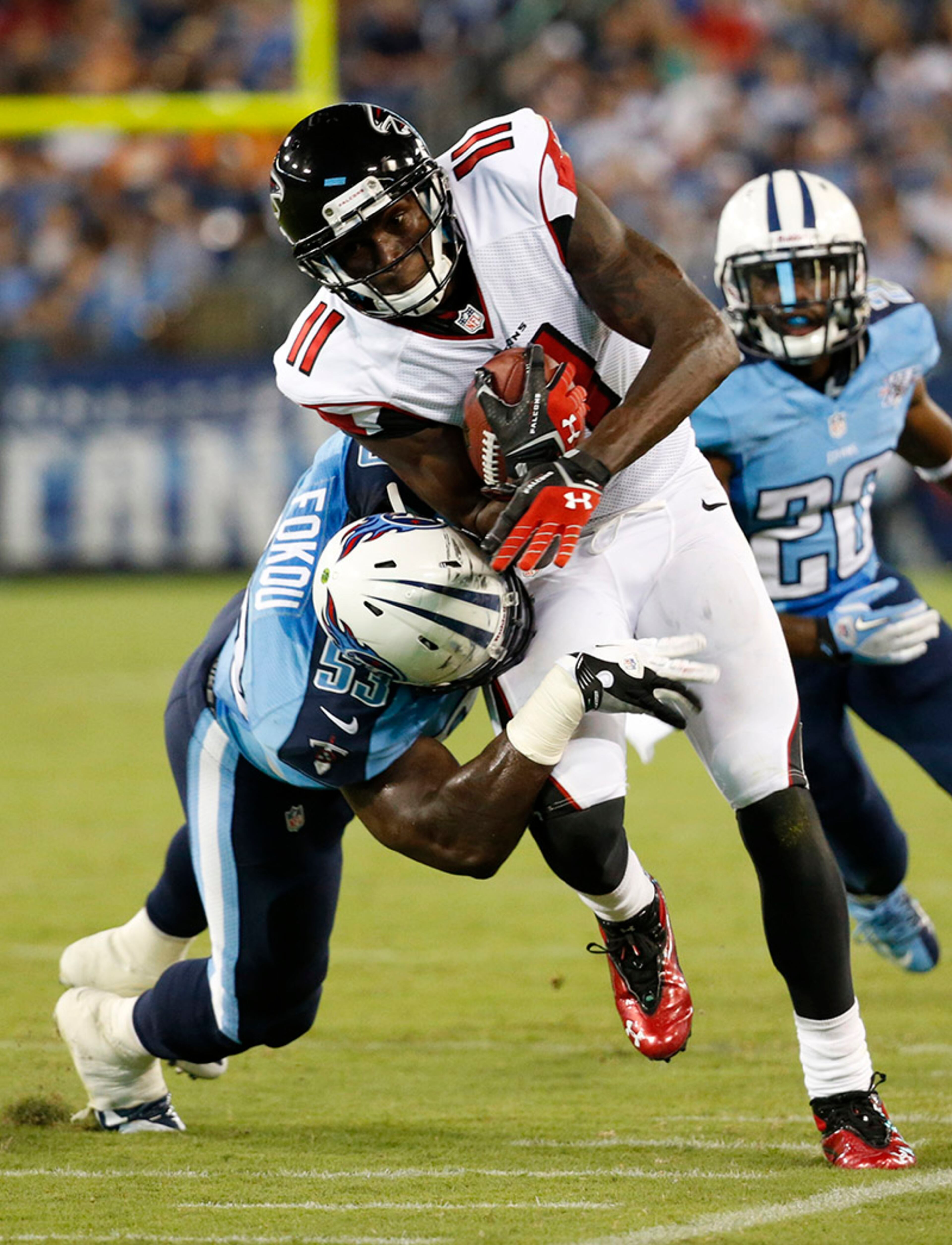 Falcons wide receiver Julio Jones (11) walks the sidelines as Tennessee Titans inside linebacker Moise Fokou (53) makes the tackle.