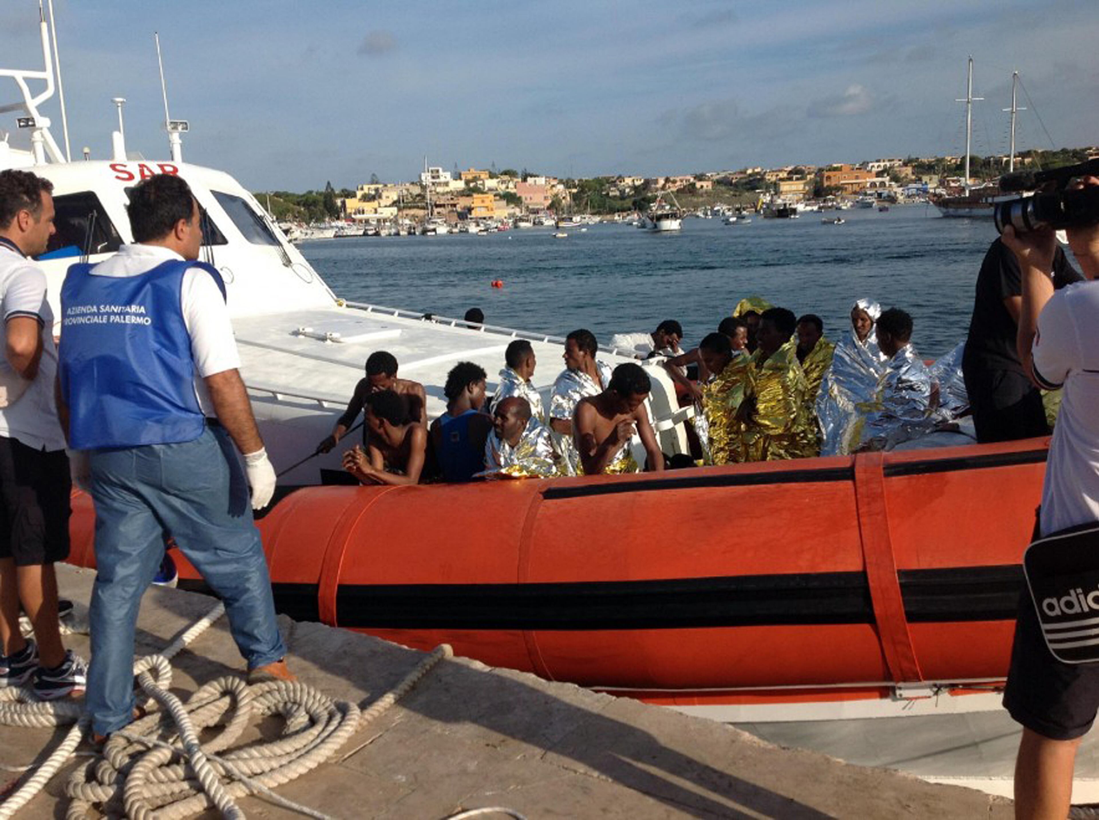 An Italian Coast Guard boat carries rescued migrants as they arrive in the port of Lampedusa on Oct. 3, 2013.