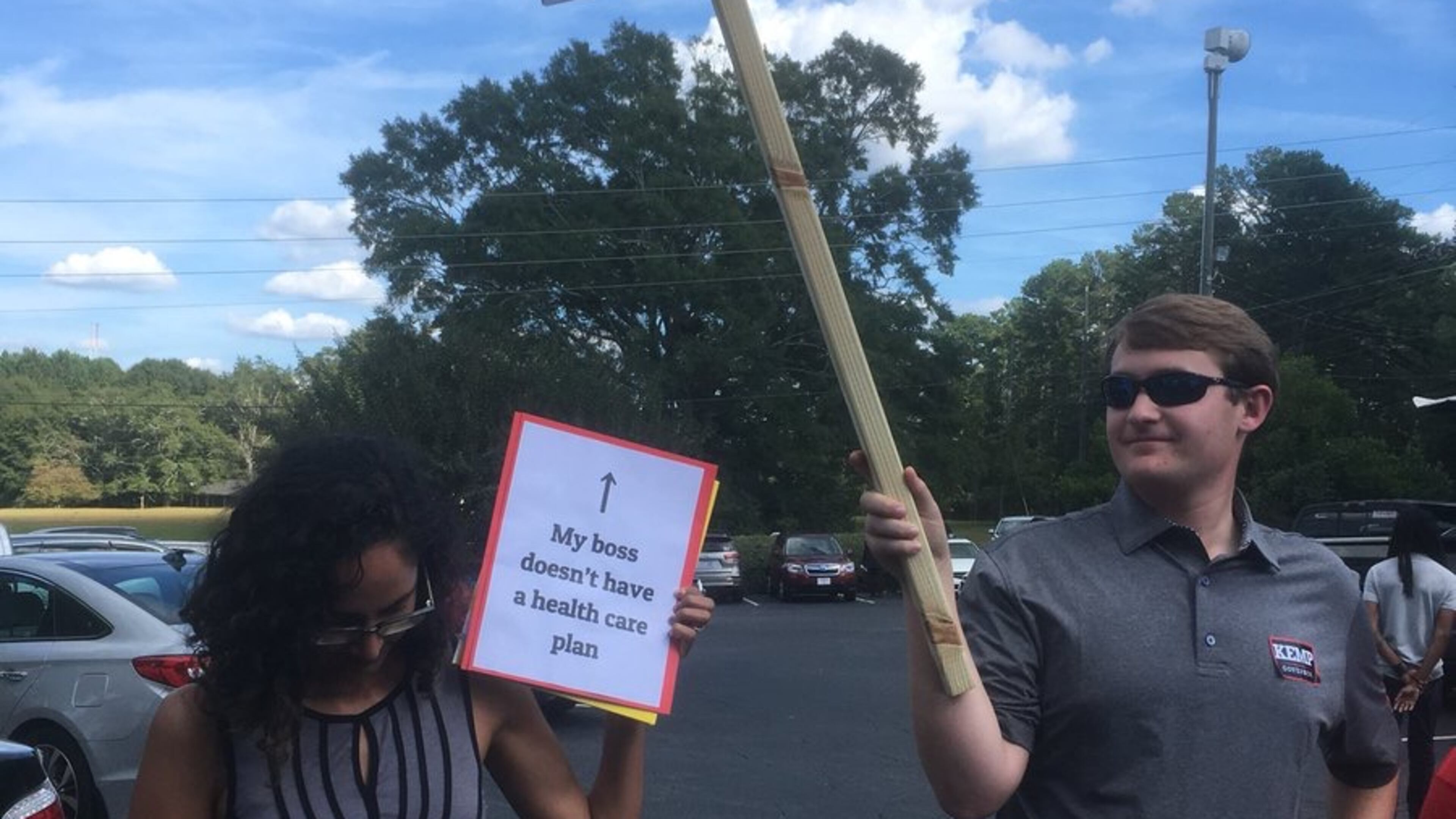 Dueling operatives at a Brian Kemp campaign rally in Newnan. Jennifer Brett/AJC