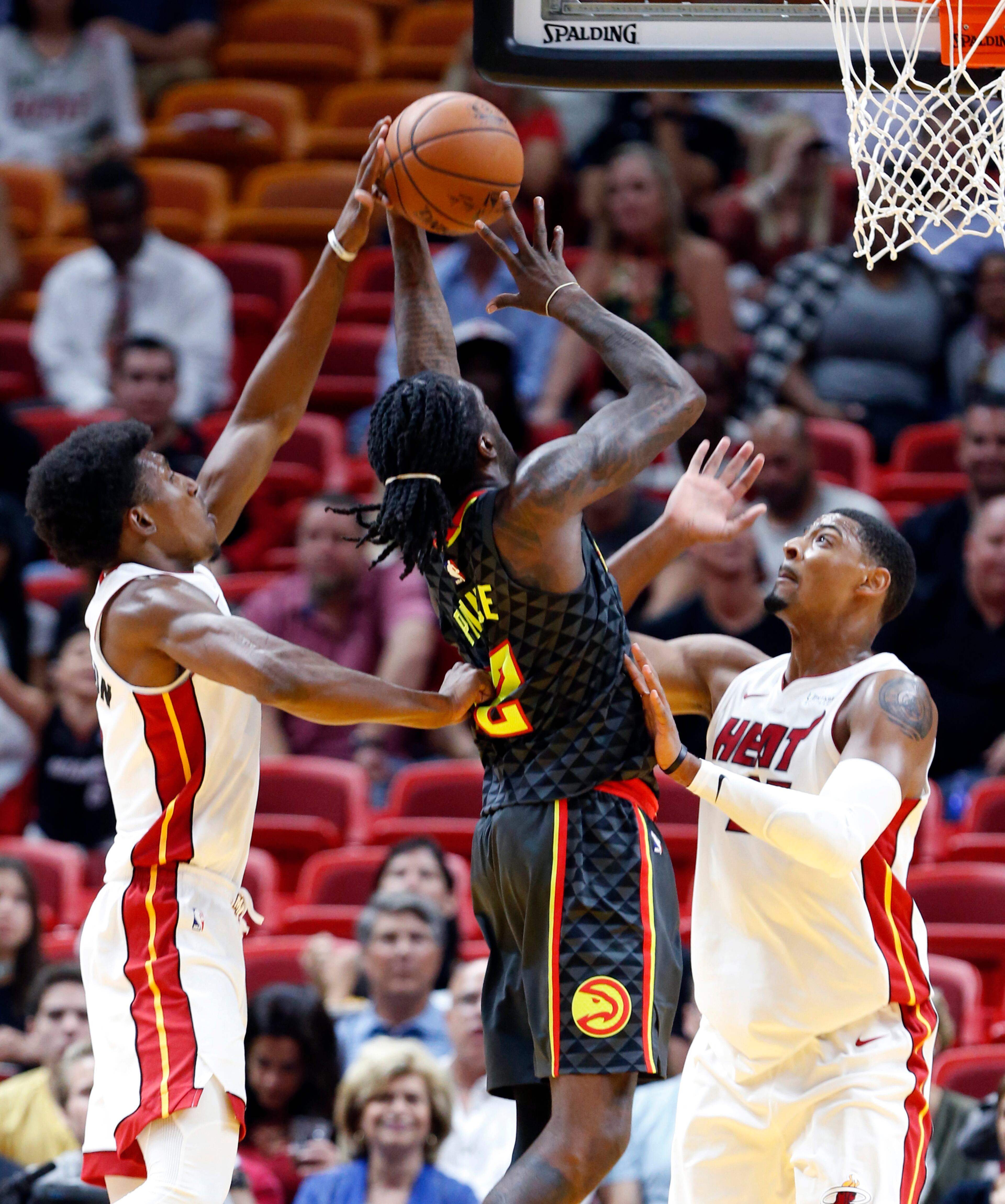 Atlanta Hawks forward Taurean Prince, center, takes a shot against Miami Heat forward Jordan Mickey, right, and guard Josh Richardson during the first half of an NBA basketball game, Monday, Oct. 23, 2017, in Miami. (AP Photo/Wilfredo Lee)