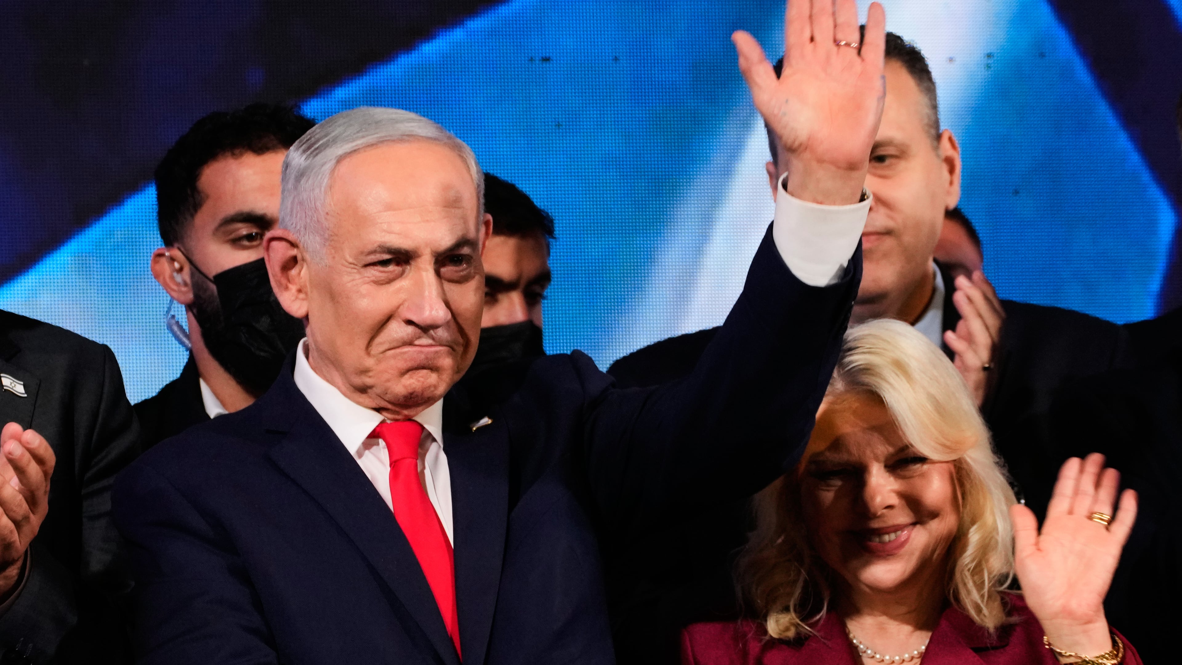 Israeli Prime Minister Benjamin Netanyahu, accompanied by his wife, Sara, waves to supporters at Likud party headquarters in Jerusalem after the release of the first exit poll results in Israel's general election, Wednesday, Oct. 28, 2026. (AP Photo/Ohad Zwigenberg)