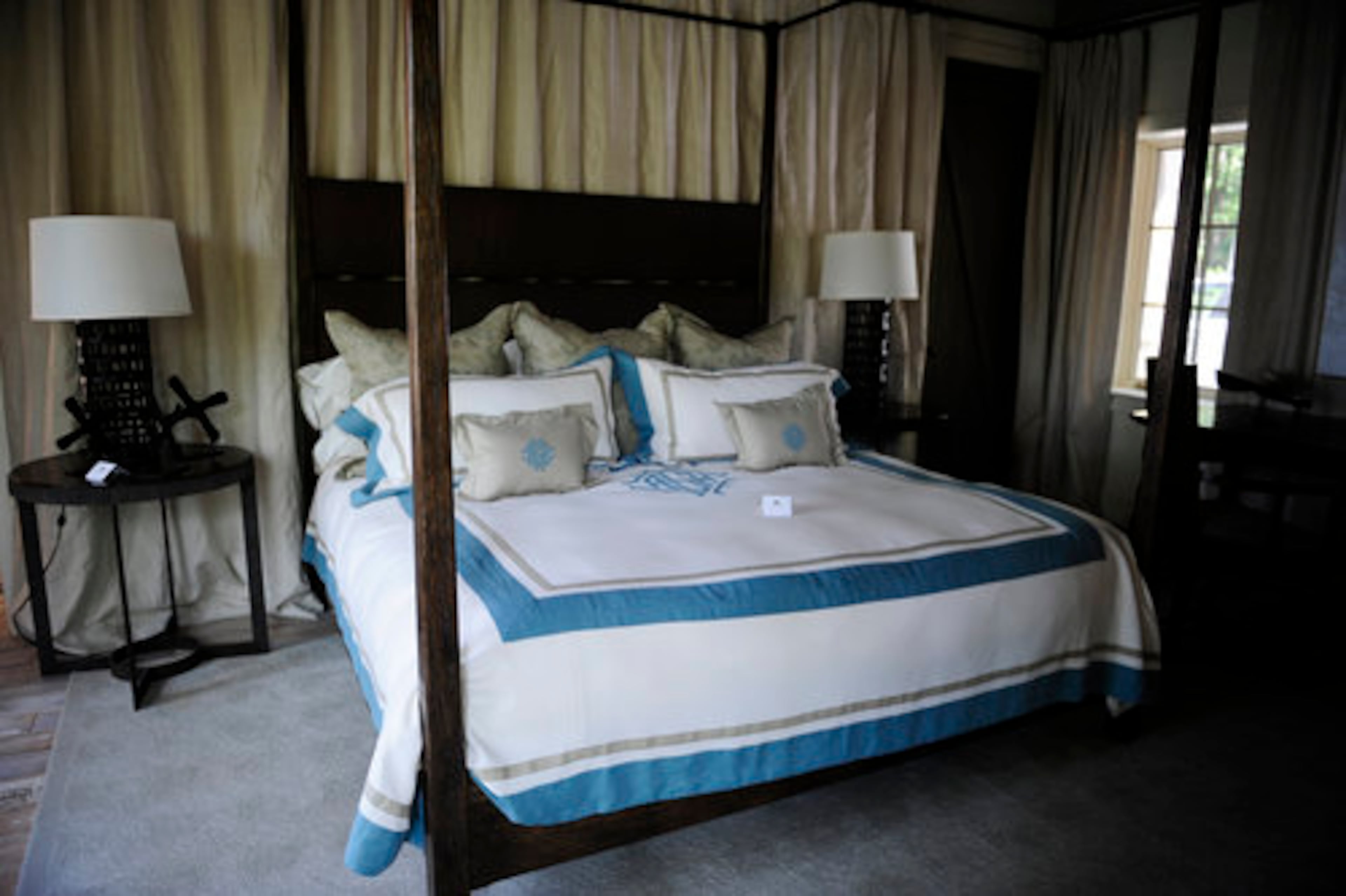 The master bedroom has a sweeping, pooled linen drapery wall that adds serenity and an intimate feel. Webb said her client wanted the drapery to block light for the occasional weekend morning snooze.