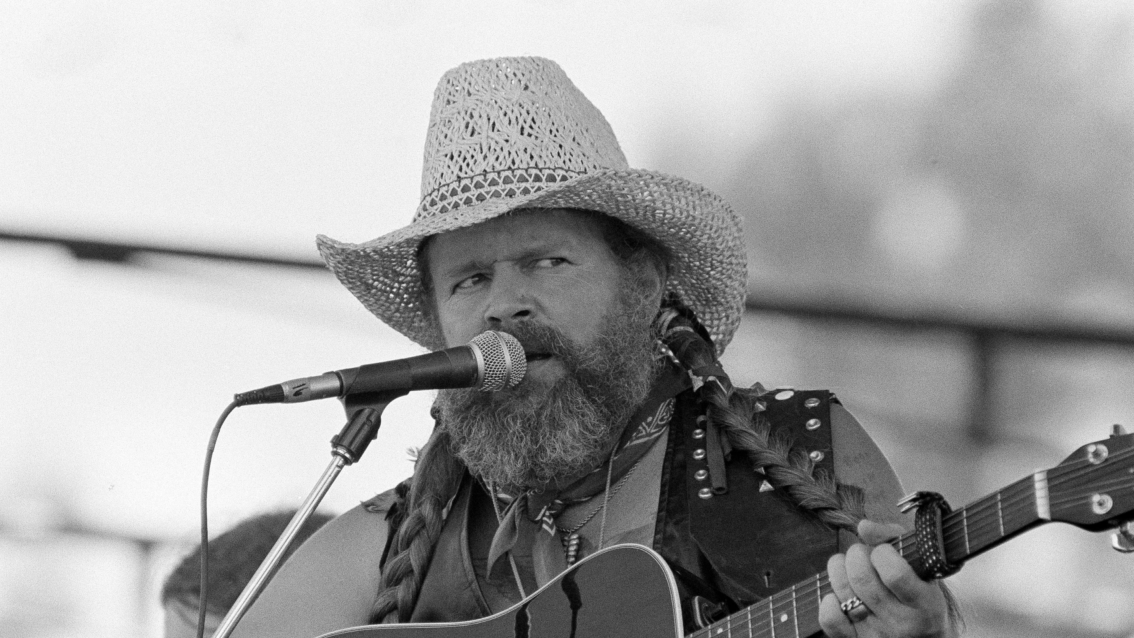 FILE - David Allan Coe, sporting Willie Nelson braids, performs at the Willie Nelson July 4th Picnic, on July 4, 1983 at Atlanta International Raceway in Hampton, Ga. (AP Photo/Rudolph Faircloth, File)