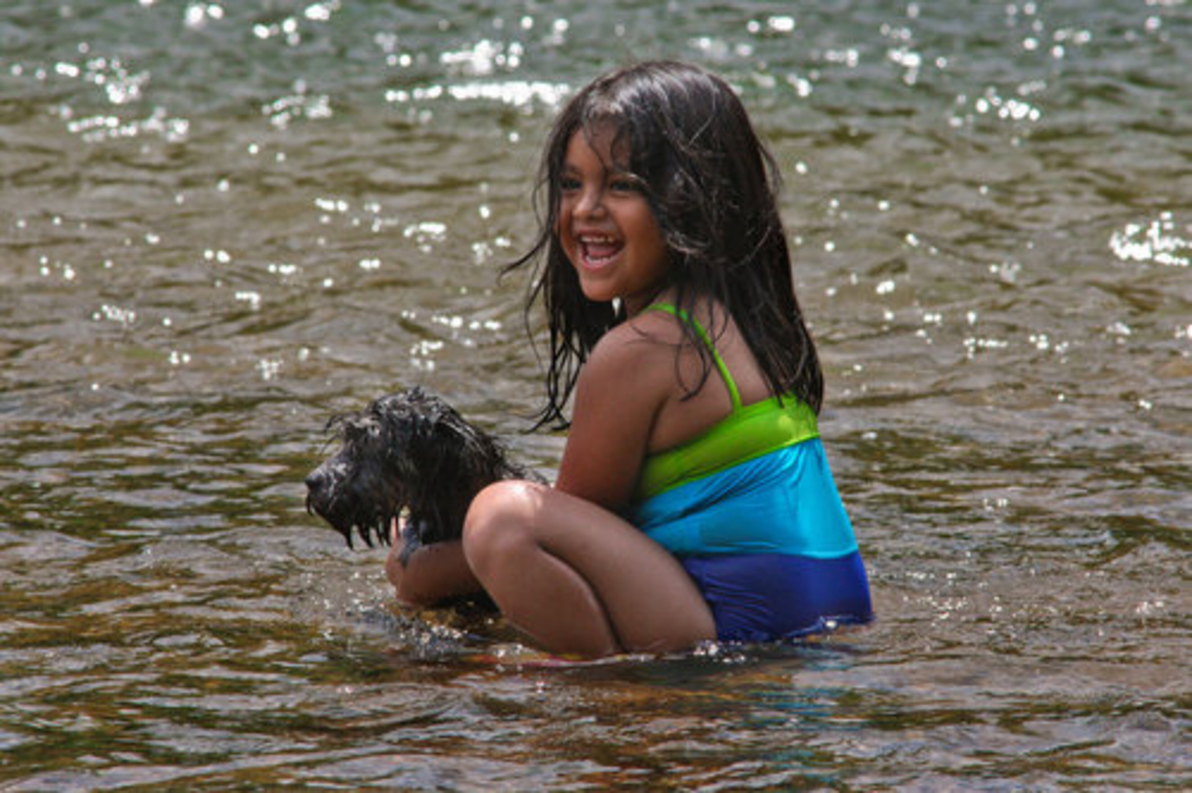 Emily Cona, 4, plays with her four-month-old terrier puppy Baby as she wades in the Chattahoochee River in Vinings on Friday. The Chattahoochee River National Recreation Area's Paces Mill offers 3.5 miles of trails and plenty of places to wade fish or fish from shore. The word Chattachoochee means painted rock in the Cherokee language.