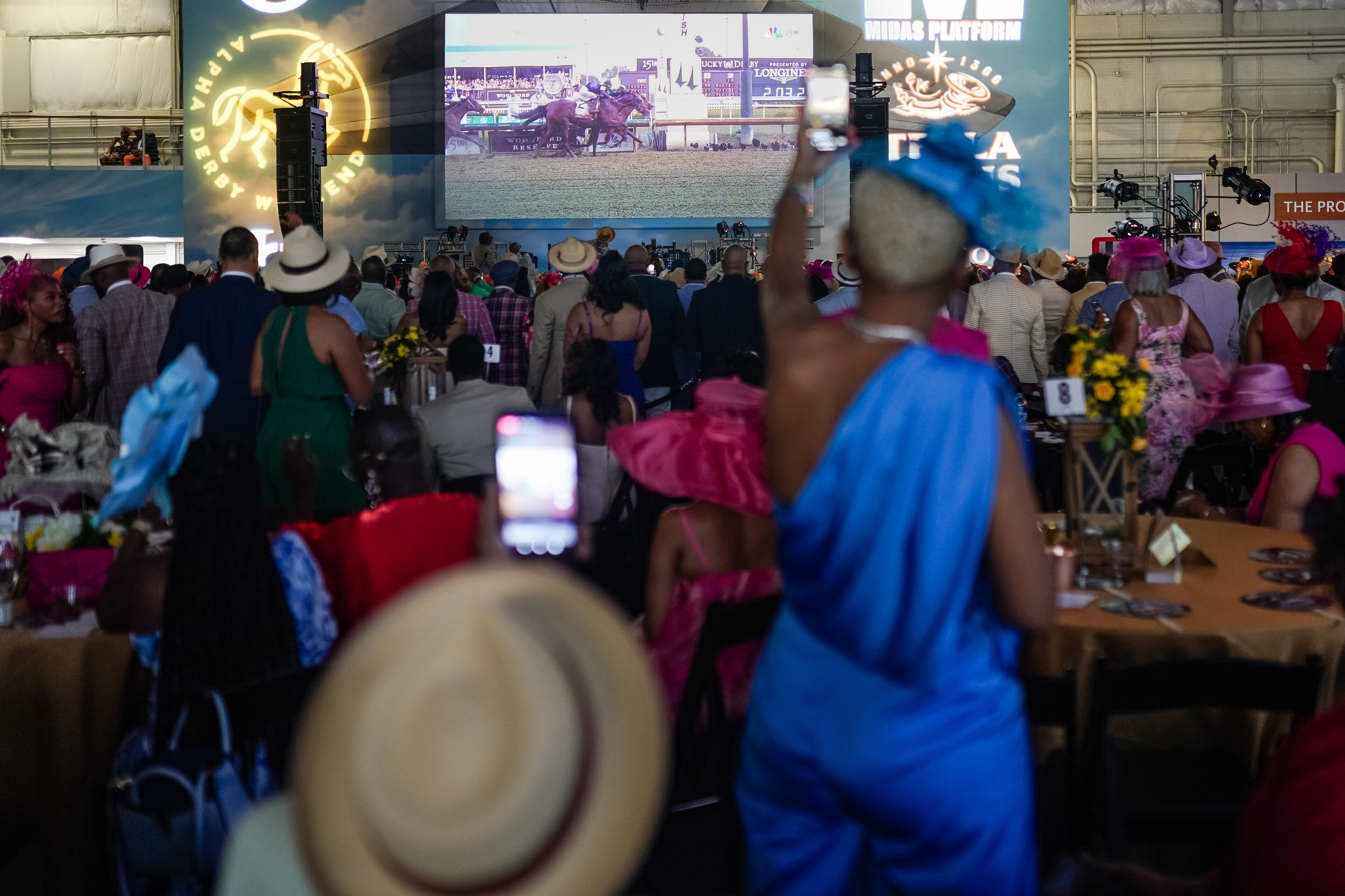 Attendees watch the Kentucky Derby, a Kentucky-Derby-themed event that raises thousands for scholarships, at the Delta Flight Museum on Saturday, May 4, 2024, in Atlanta. (Elijah Nouvelage for The Atlanta Journal-Constitution)