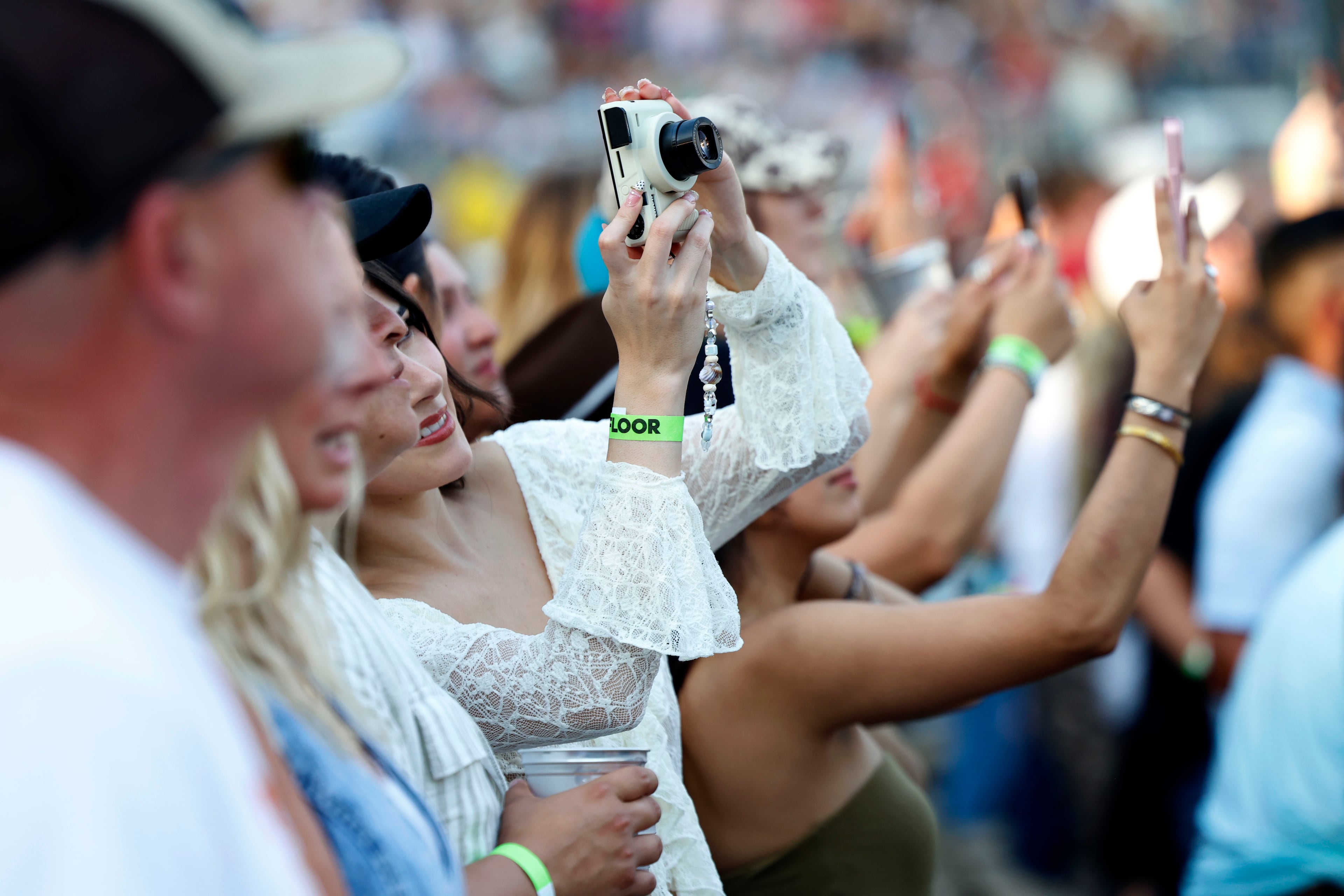 June 13, 2026 - Atlanta, GA: Audience members taking photos at the Braves Country Fest, an inaugural, a first of its kind celebration of Braves baseball and country music, headlined by Cody Johnson, Ella Langley, ERNEST, and Mackenzie Carpenter inside Truist Park Saturday. (Akili-Casundria Ramsess/For the AJC)