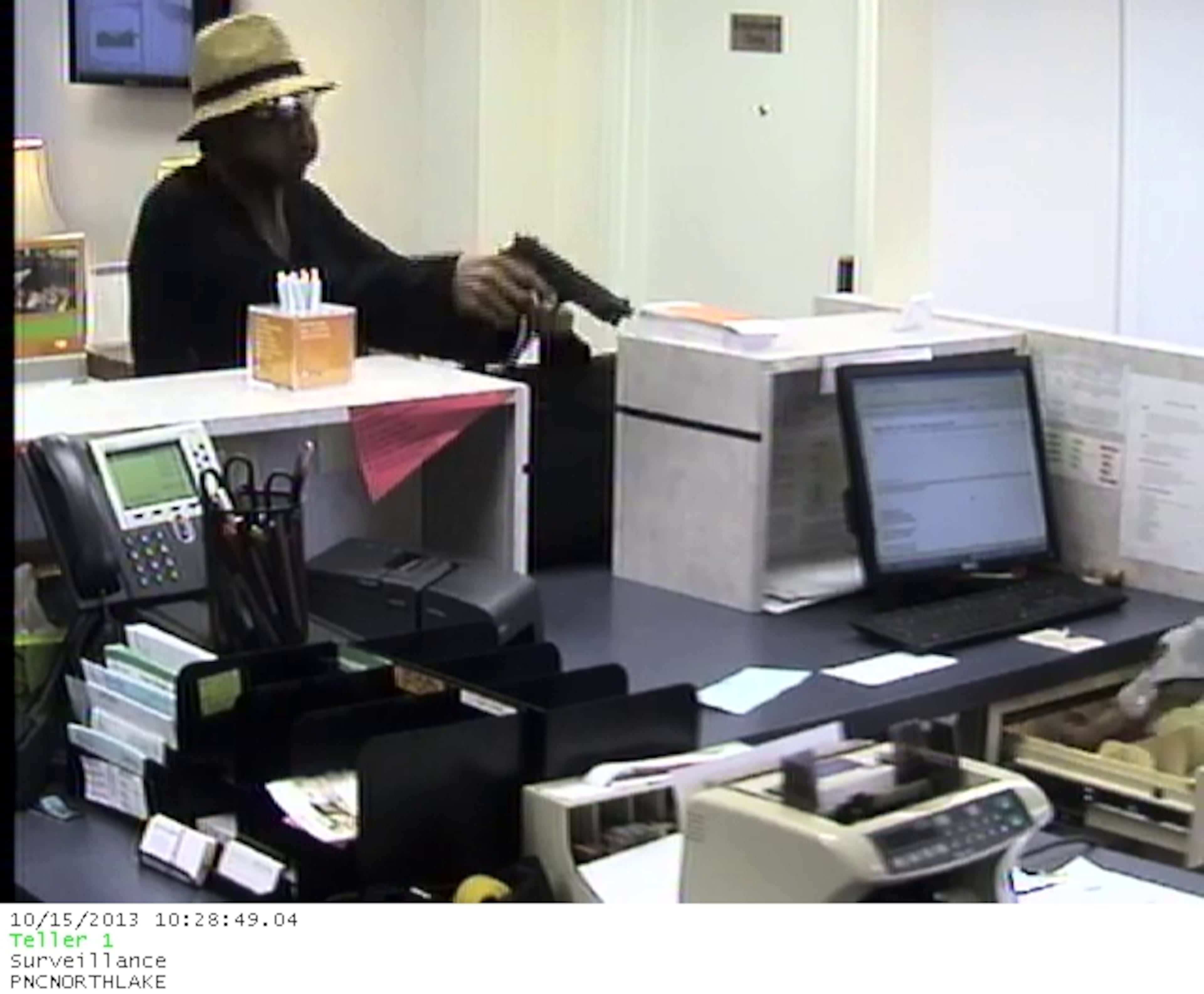 The robber then jumped over the teller counter with a black canvas bag in his other hand and began gathering money from several of the teller drawers.