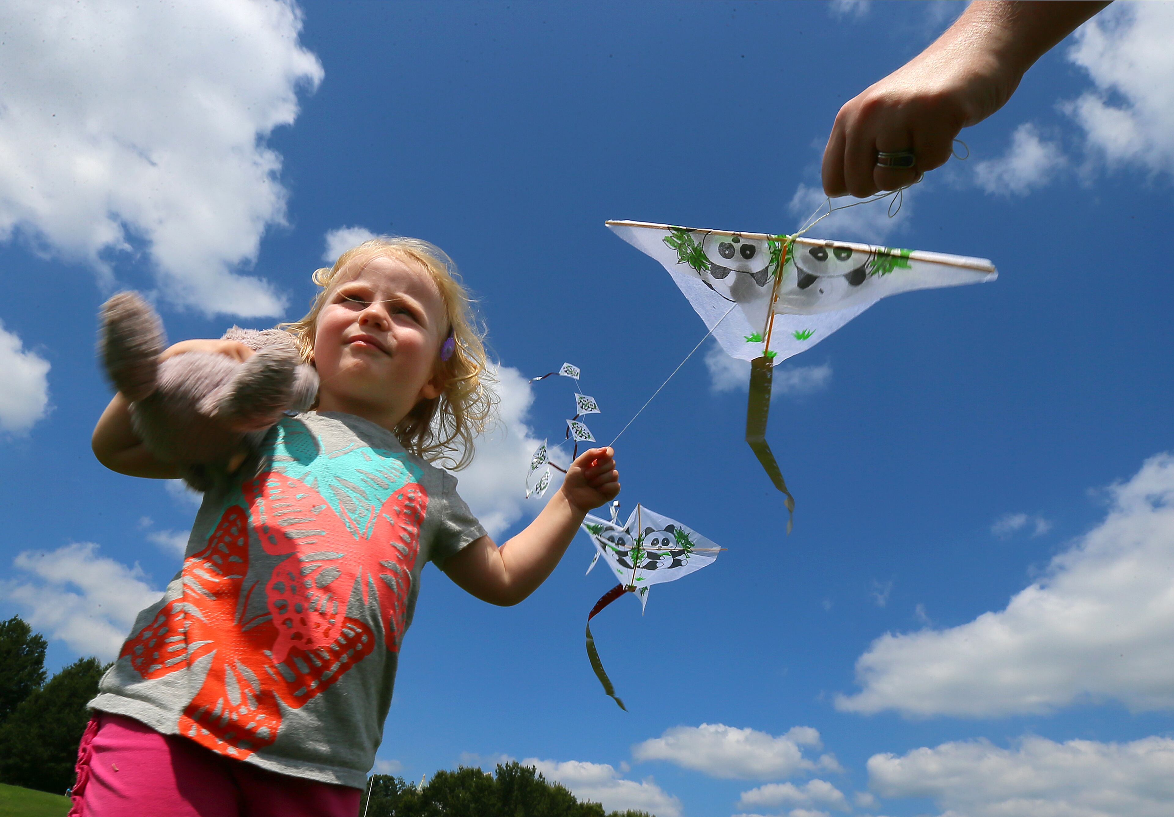 Eleanor Shore, 2, and her mom Fiona Havers, Atlanta, take advantage of the blue skies to launch a string of kites during the 13th Festival Peachtree Latino at Piedmont Park on Sunday.
