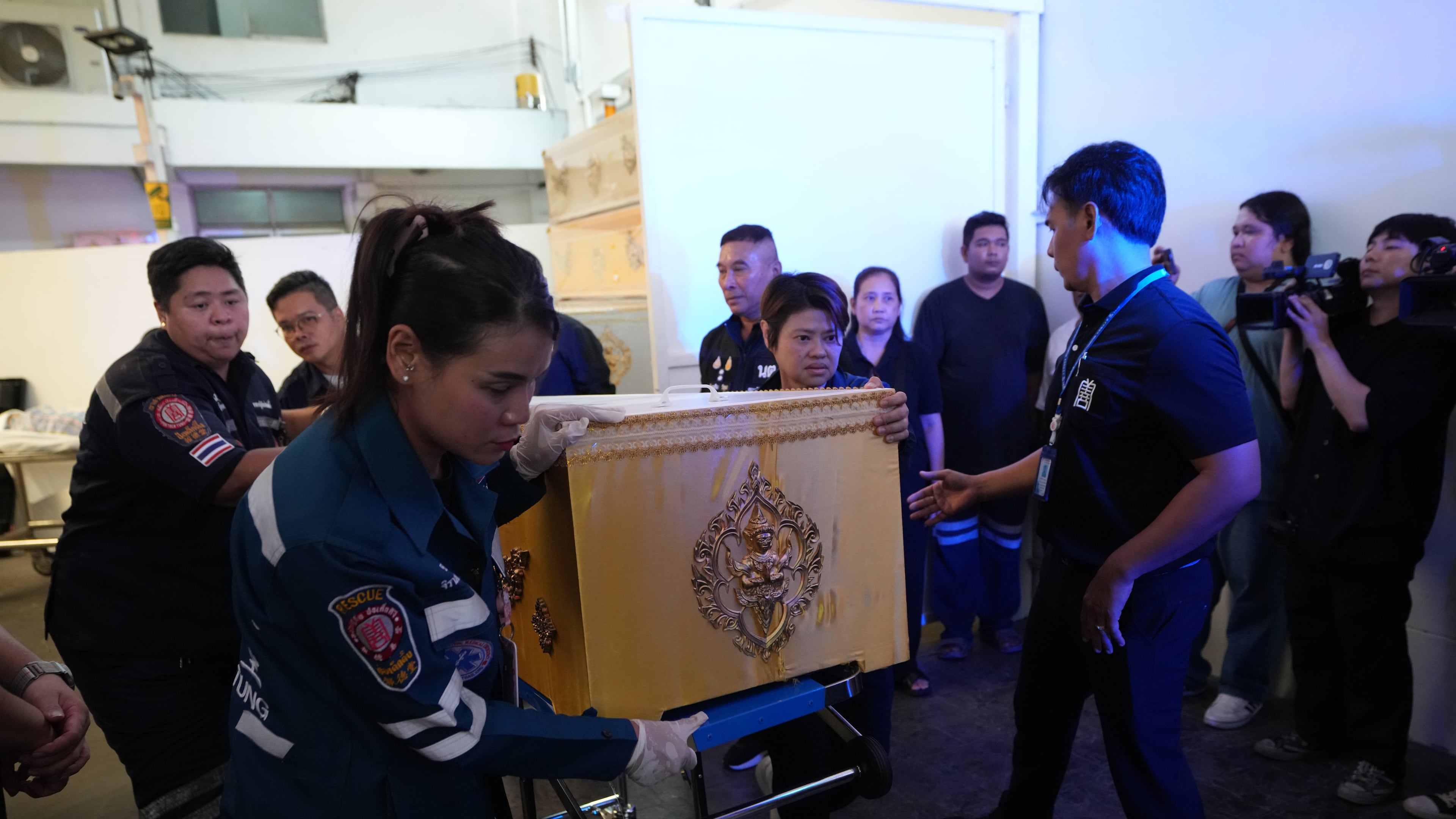 A coffin containing the body of a victim of Friday's shooting at the Debsirin Nonthaburi School, is brought in a stretcher at a police hospital in Bangkok,Thailand, Saturday, Aug. 8, 2026. (AP Photo/Sakchai Lalit)