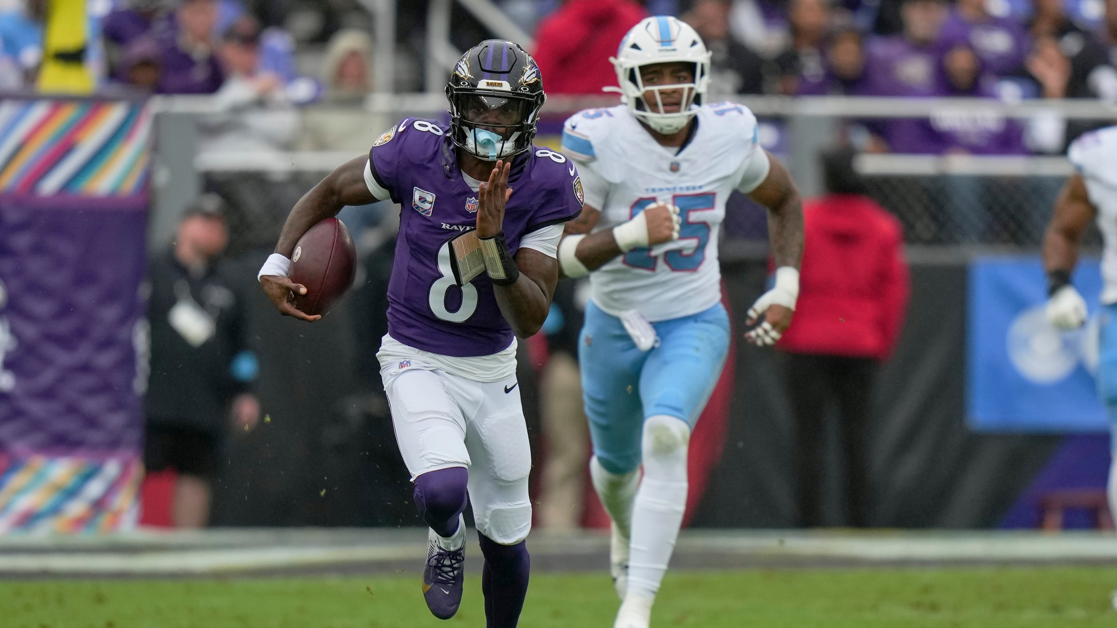 Baltimore Ravens quarterback Lamar Jackson (8) runs the ball past Tennessee Titans defensive end Keldric Faulk (15) during the first half of an NFL football game in Baltimore, Sunday, Oct. 4, 2026. (AP Photo/Stephanie Scarbrough)