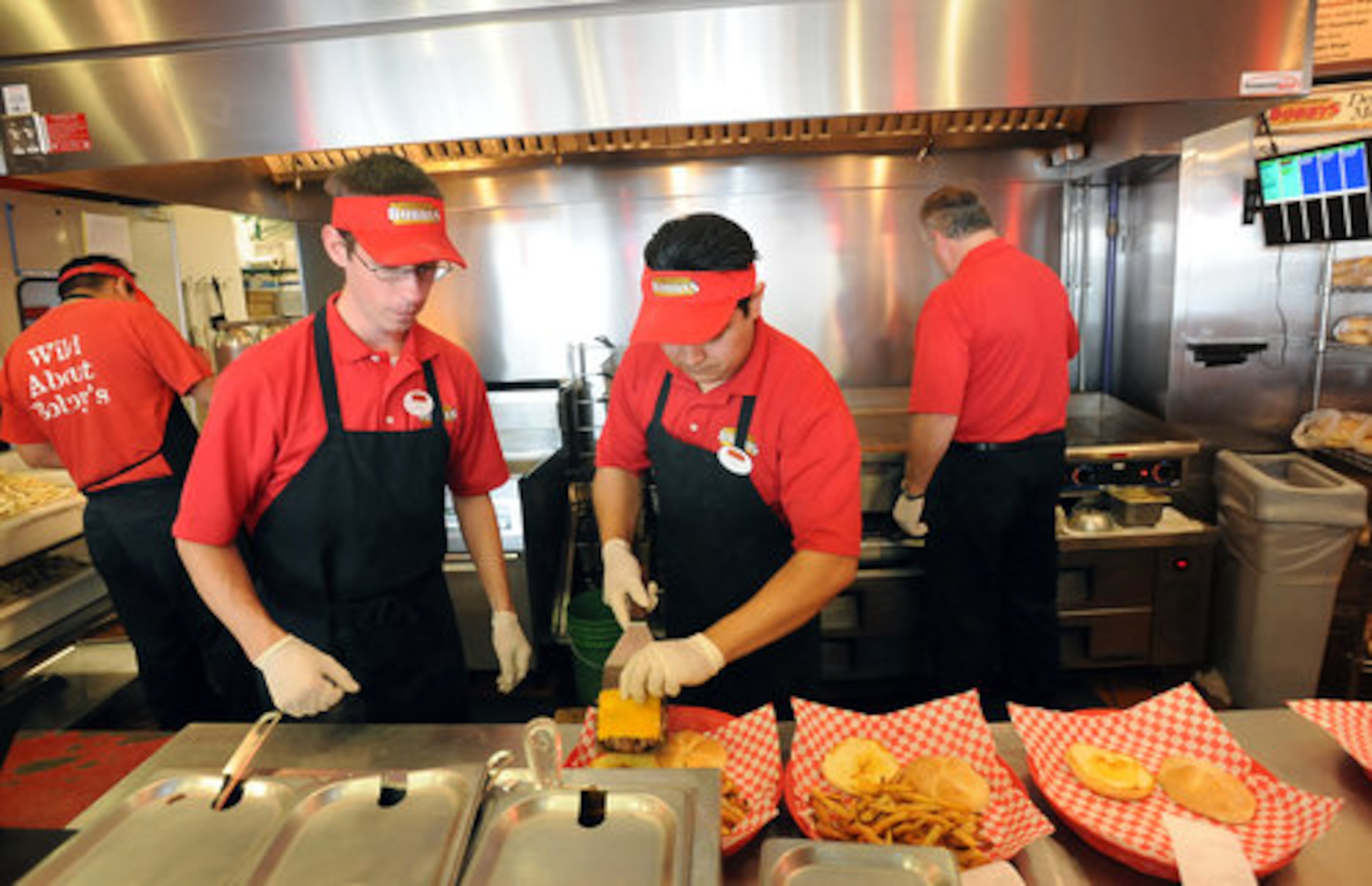 Employees Gulledge (left) and Sergio Banuelos prepare burgers. Cheeseburger Bobby's features gourmet burgers, fresh-cut fries and frozen custard.