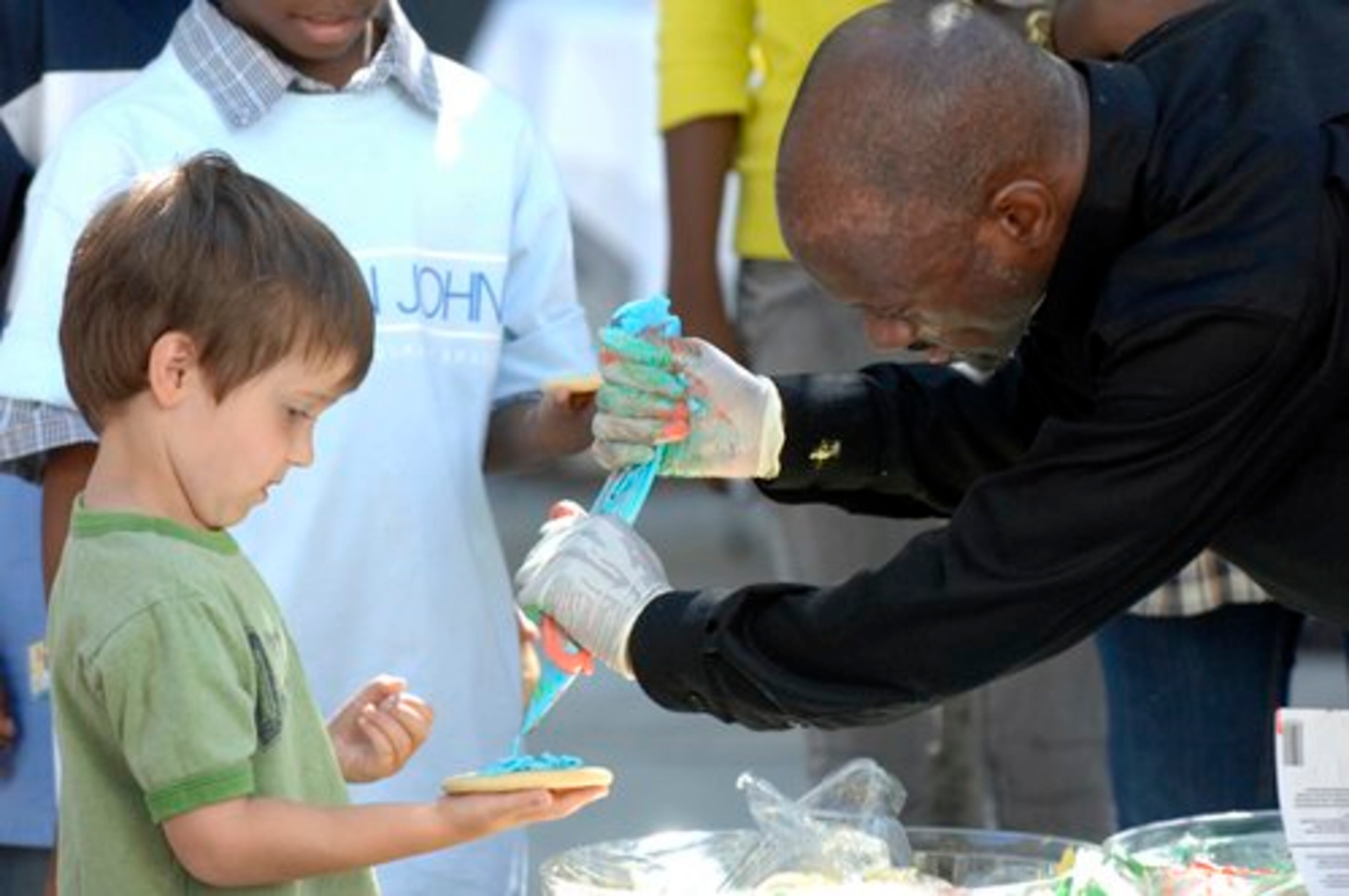 Harry Clay with LPA decorates a cookie for Charlie McDonough, 4, of Marietta at the Target Family Fun Day at Woodruff Arts Center Sunday.Kent D. Johnson, kdjohnson@ajc.com