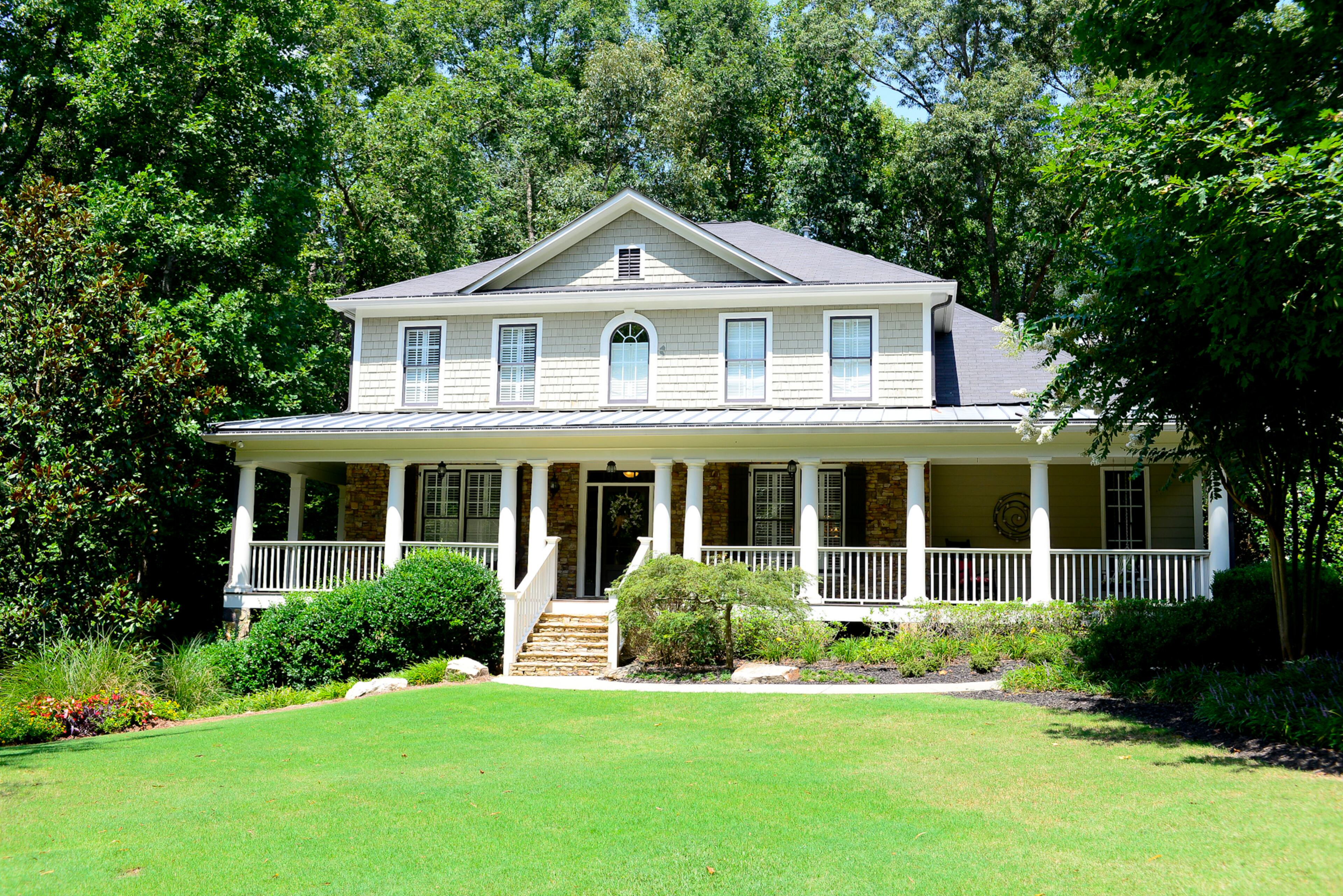 A wraparound porch and columns signals the home's Southern traditional style. The four-bedroom, four-and-a-half bath Alpharetta house was built by Hedgewood in 2001 for the Burns family. The exterior is painted Behr's Mushroom Basket, with Benjamim Moore's Walrus Tusk for the trim and Sherwin-Williams' Black Fox for the shutters.--Text by Lori Johnston