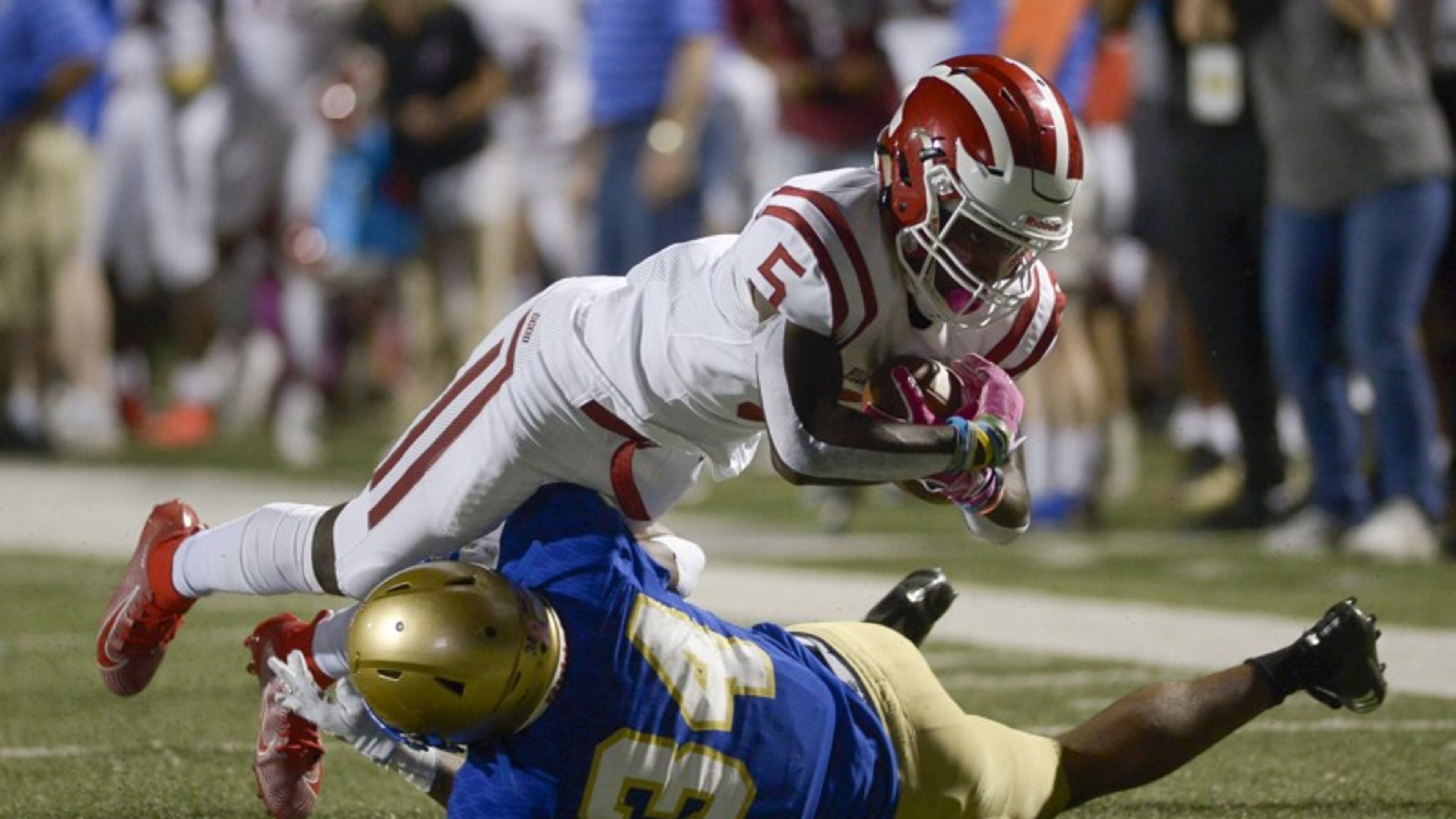 McEachern defensive back Victor Okafor (24) makes a tackle on Hillgrove wide receiver Braylen Howard (5) as he runs the ball in the first half of Friday's game at McEachern.