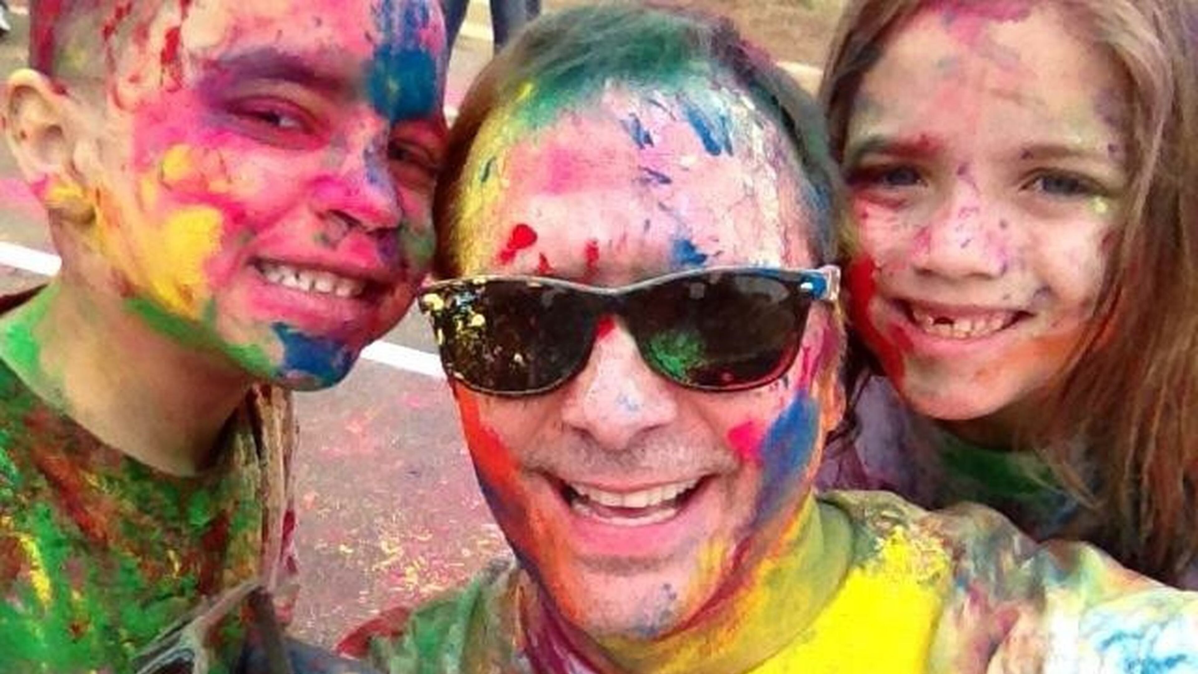 Jim Bass with his daughter Katherine and son Will at Holi, an Indian festival of colors. Bass and his husband, Ken Adcox, adopted the siblings when Bass’ sister, a cocaine addict, could no longer care for them. CONTRIBUTED