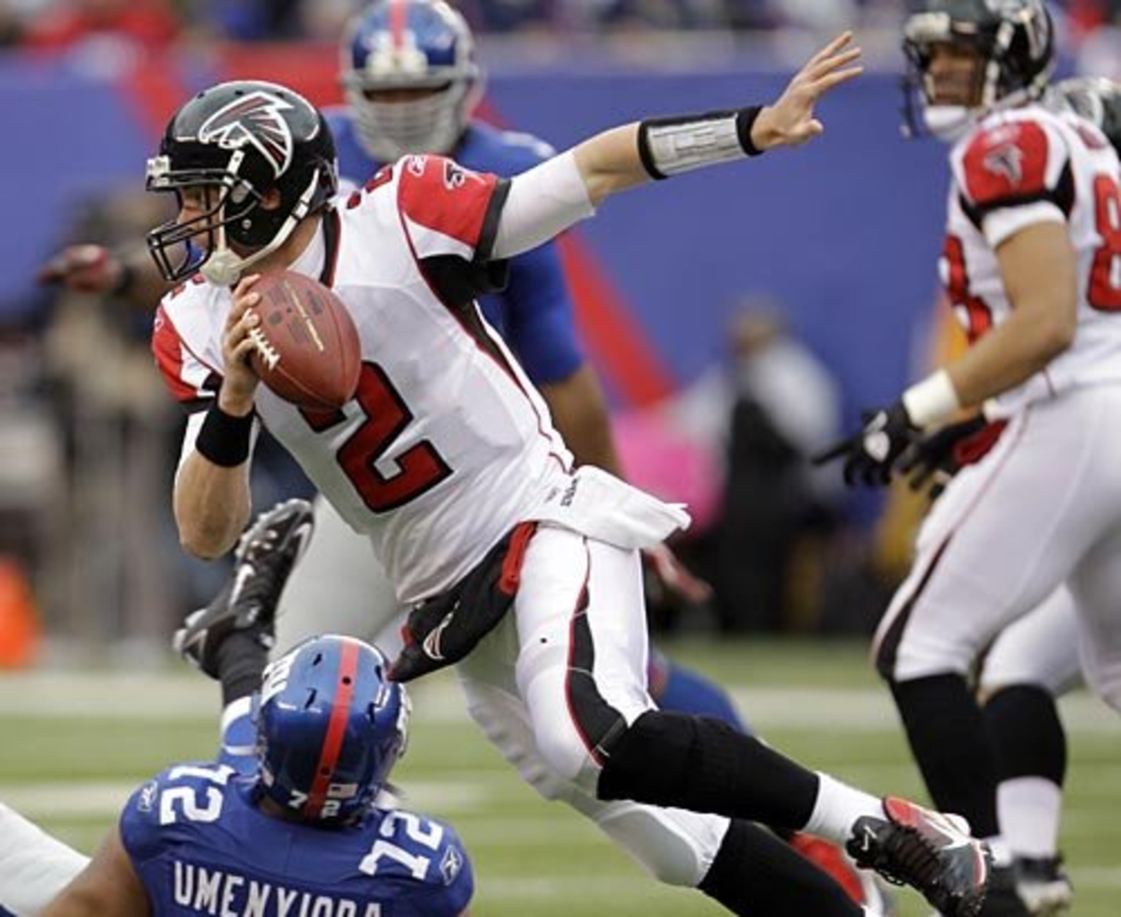 Falcons quarterback Matt Ryan (2) runs over New York Giants defensive end Osi Umenyiora (72).
